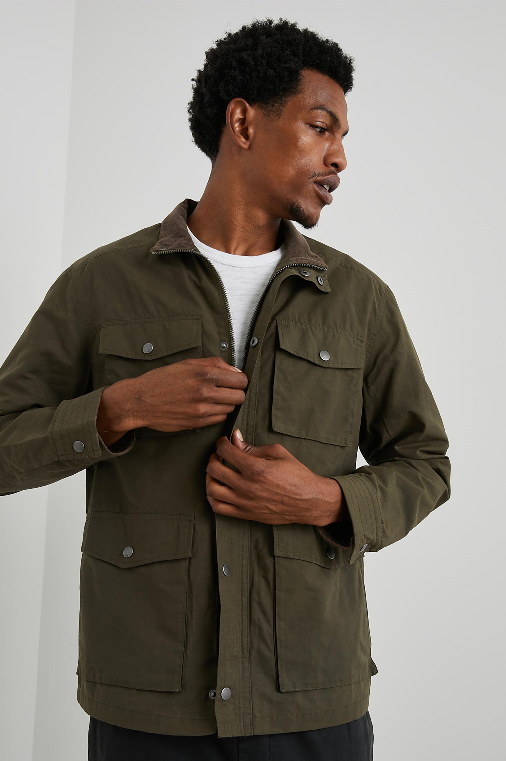 Cardiff Jacket with a Snap and Zipper Closure, Two Chest Snap Flap Pockets and Two Front Snap Flap Pockets in Dark Olive Colorway, with an Interior of Multicolor Horizontal Stripes - Front View Featured on Model  