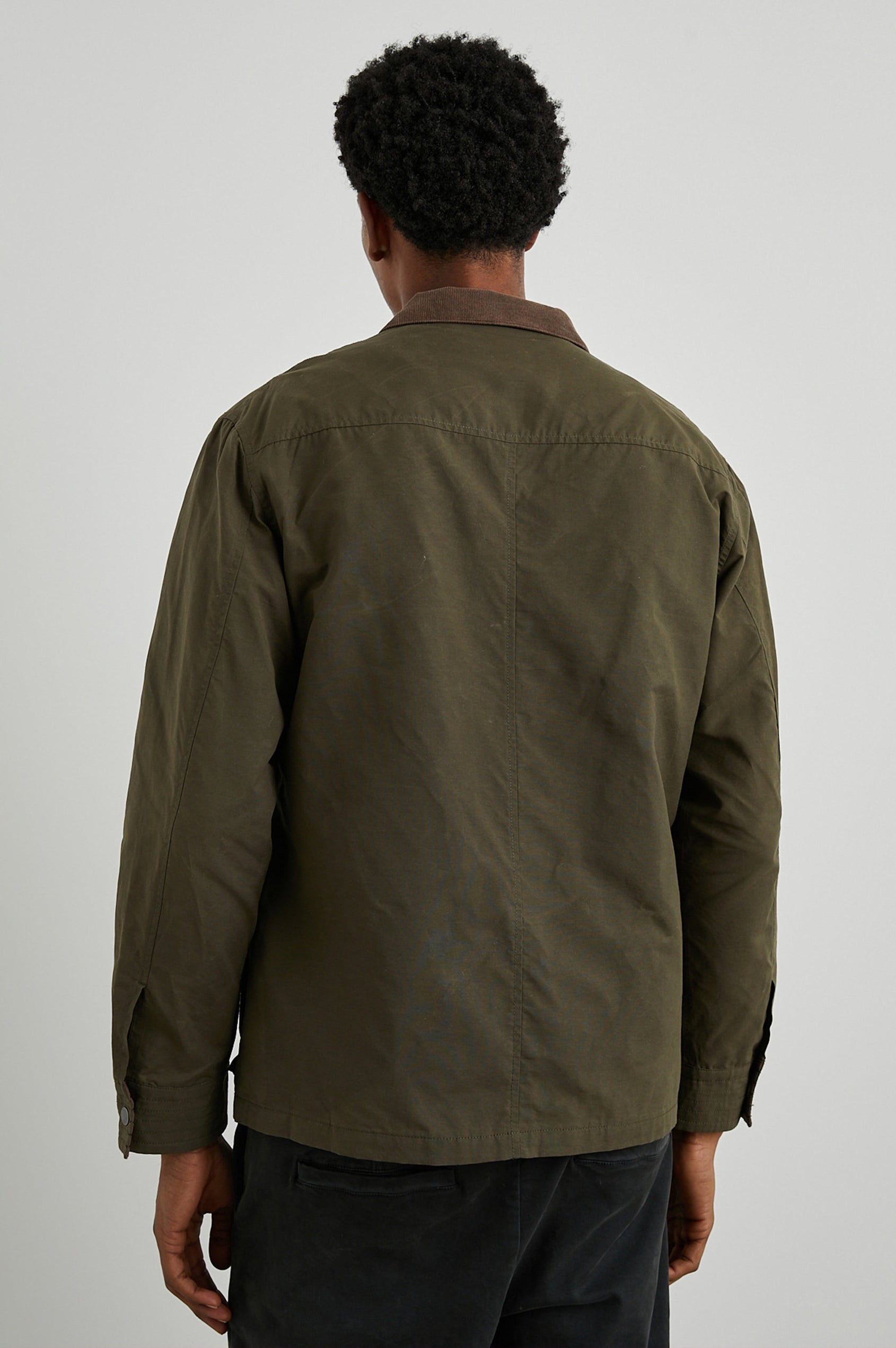 Cardiff Jacket with a Snap and Zipper Closure, Two Chest Snap Flap Pockets and Two Front Snap Flap Pockets in Dark Olive Colorway, with an Interior of Multicolor Horizontal Stripes - Back View Featured on Model  