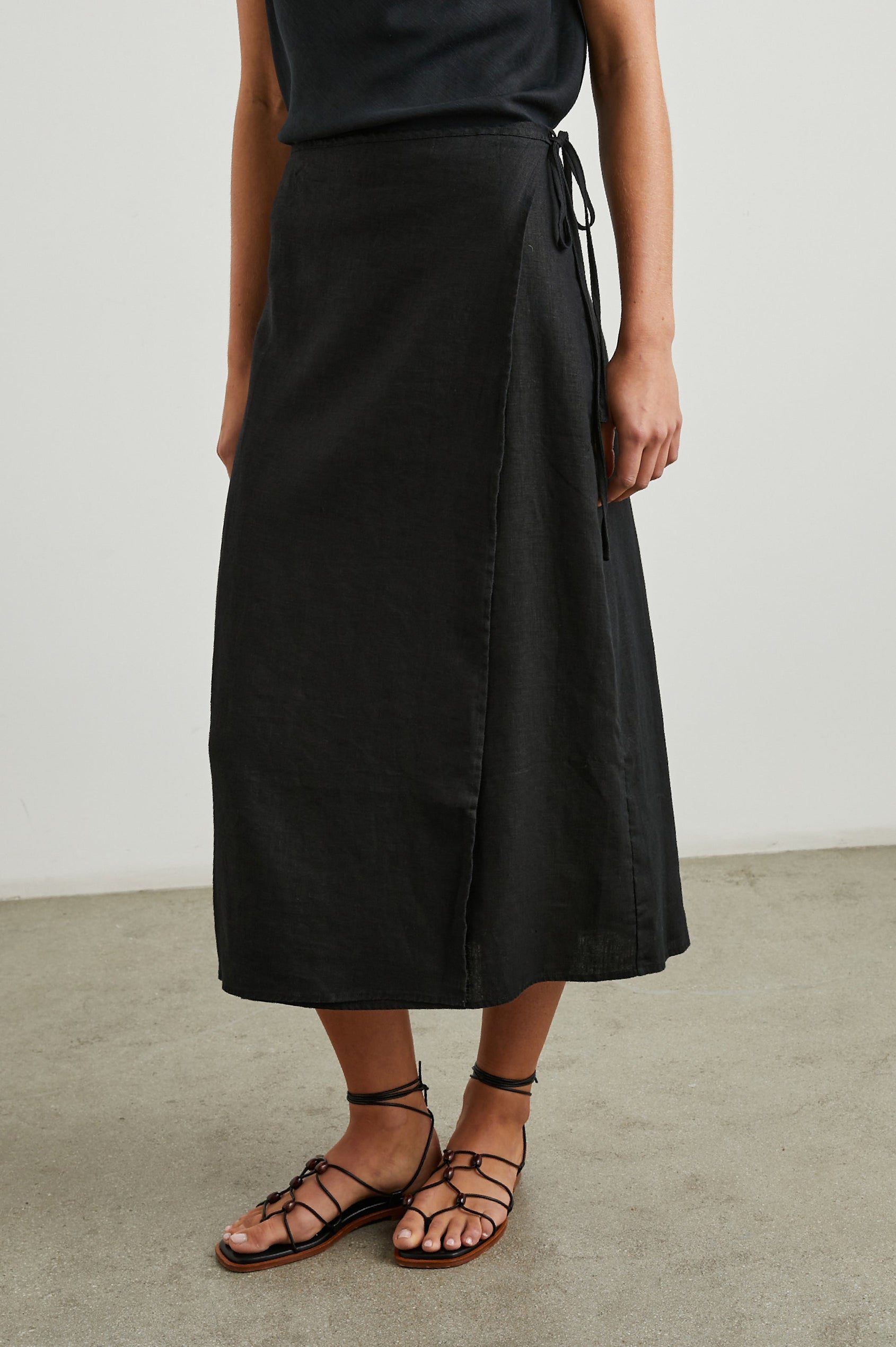 Carly Midi Wrap Skirt With a Side Tie in Black Colorway - Front View Featured on Model 