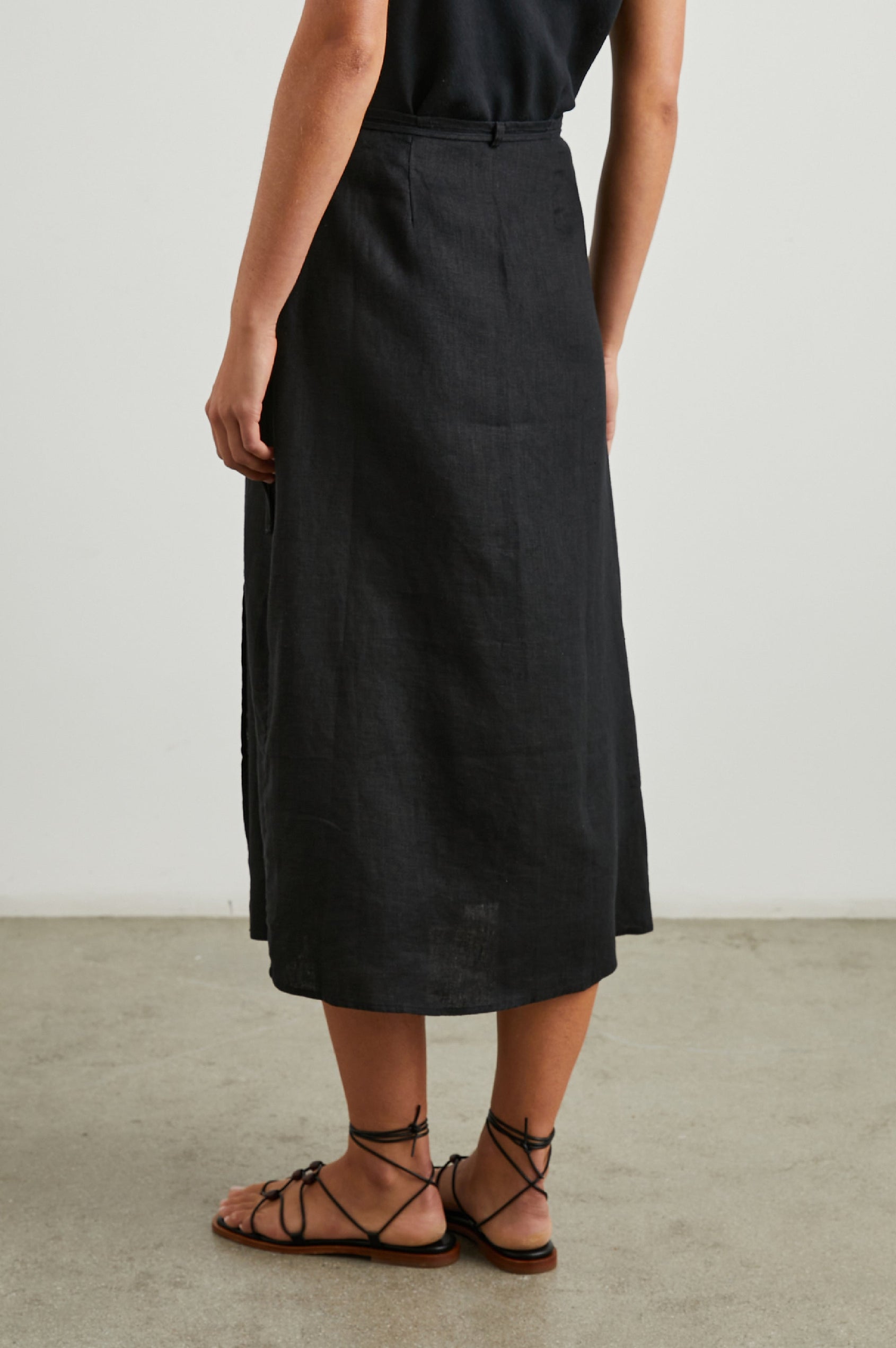 Carly Midi Wrap Skirt With a Side Tie in Black Colorway - Back View Featured on Model 