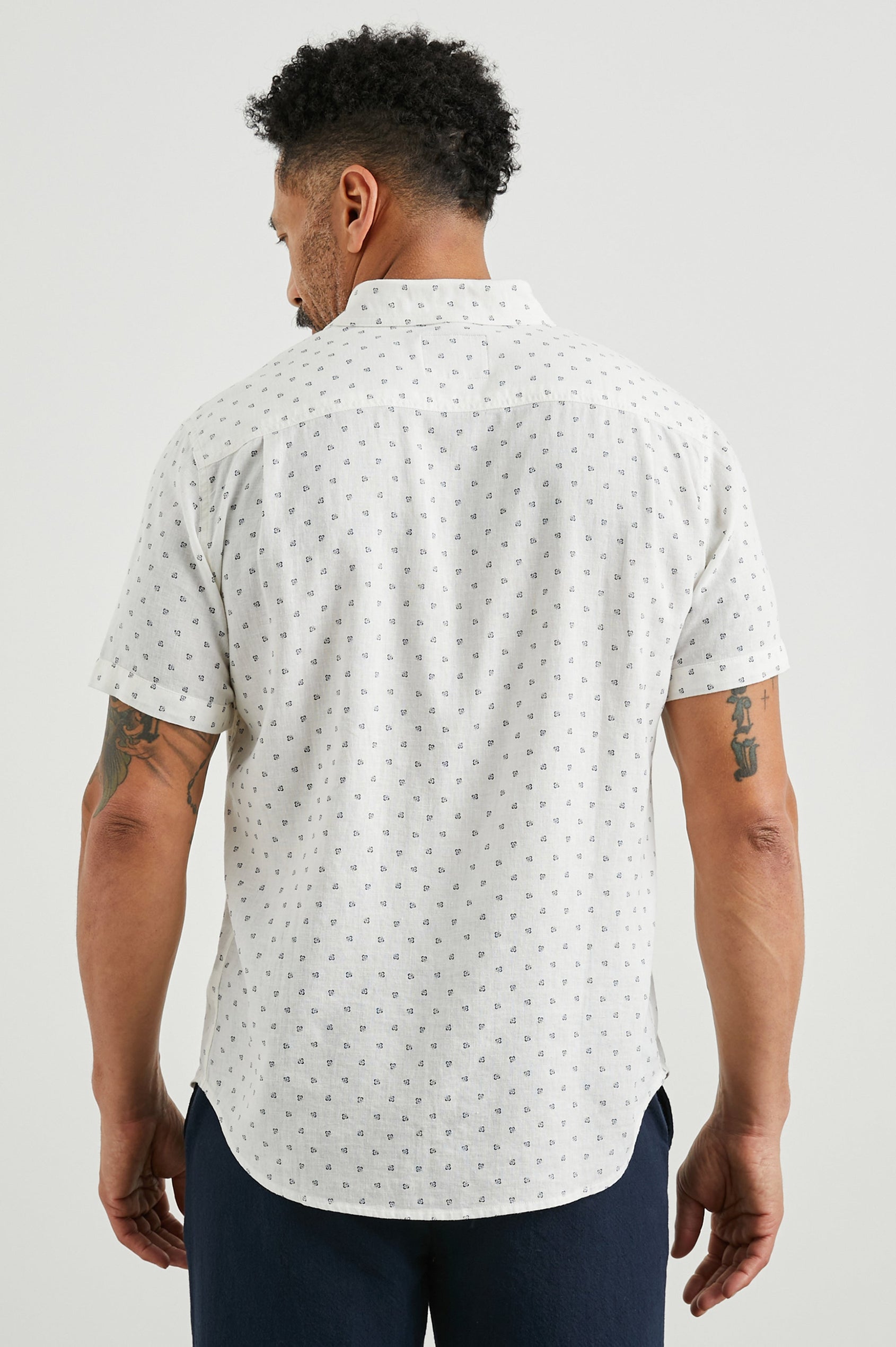 Carson Short Sleeve Button Up with a Chest Patch Pocket in Autumn Calico White Colorway, Small Blue Flowers on White- Back View Featured on Model