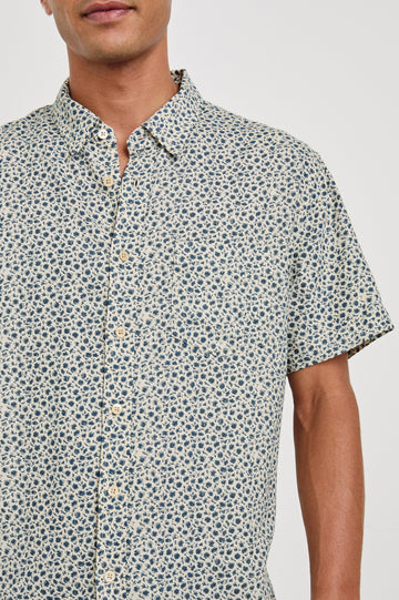 Carson linen short sleeve button down with a collar and blue botanical pattern in Autumn Daisy Ocean - close up of details on model