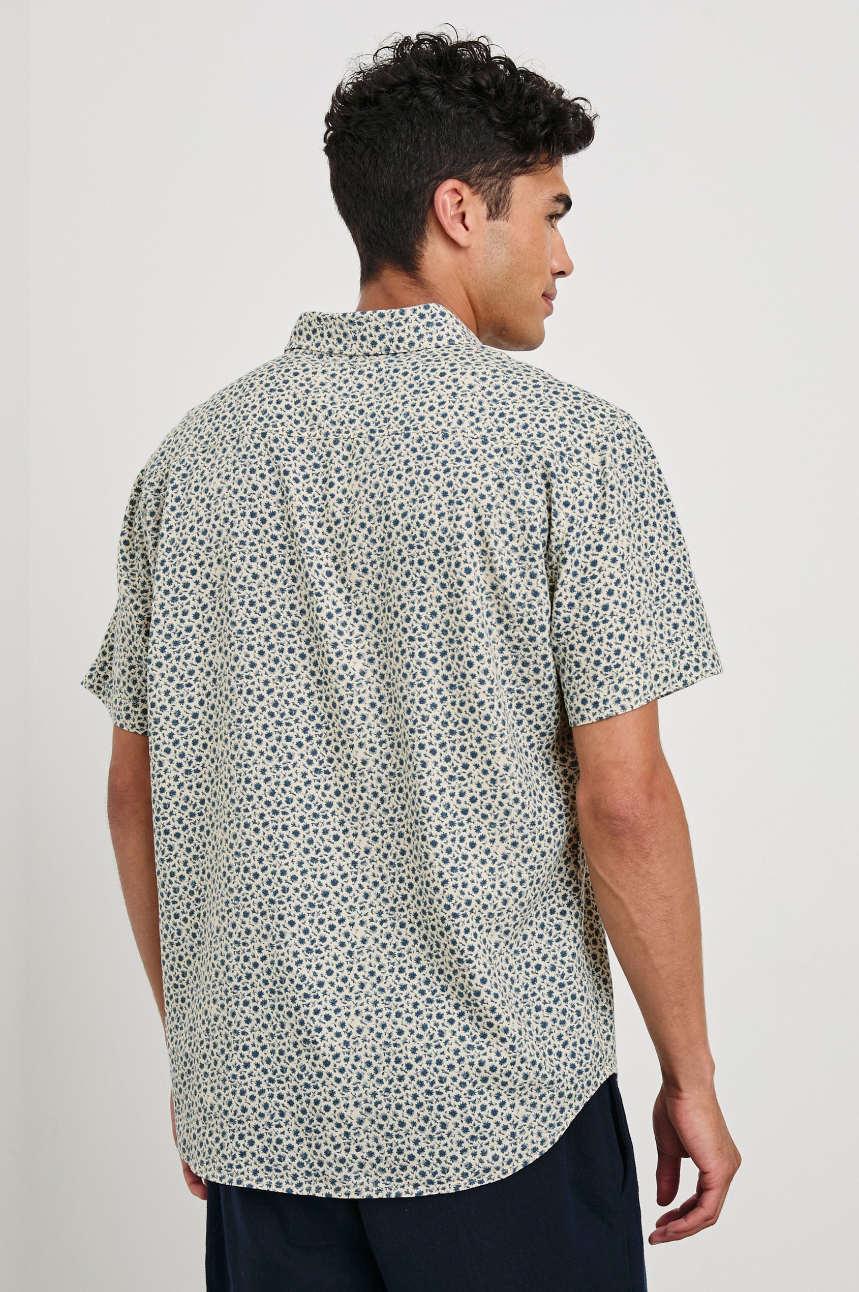 Carson linen short sleeve button down with a collar and blue botanical pattern in Autumn Daisy Ocean - back view on model