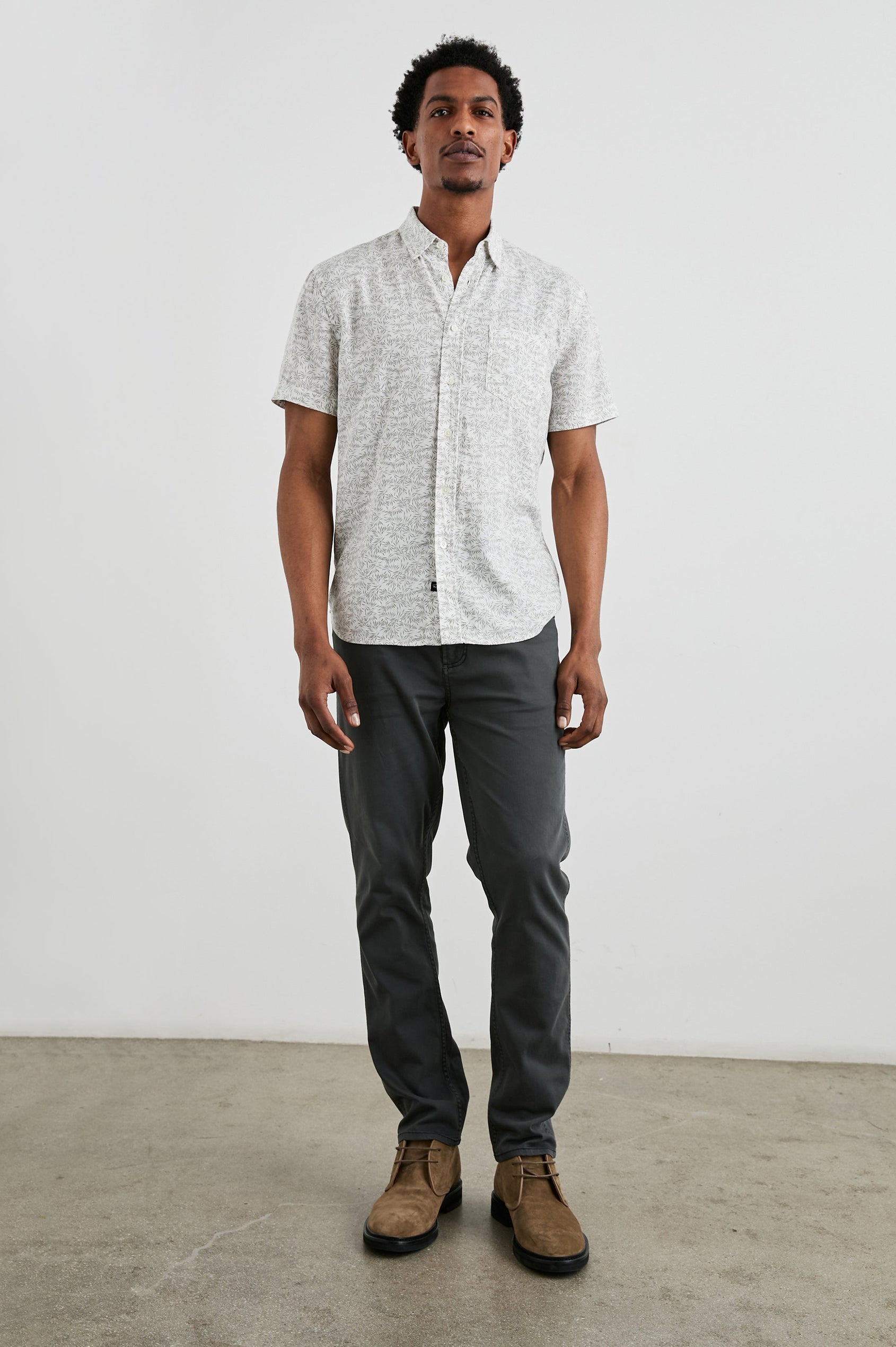 Carson Short Sleeve Button Up with a Chest Patch Pocket in Crop Circle White Colorway, Small Olive Leaves on White - Front Full Body View Featured on Model