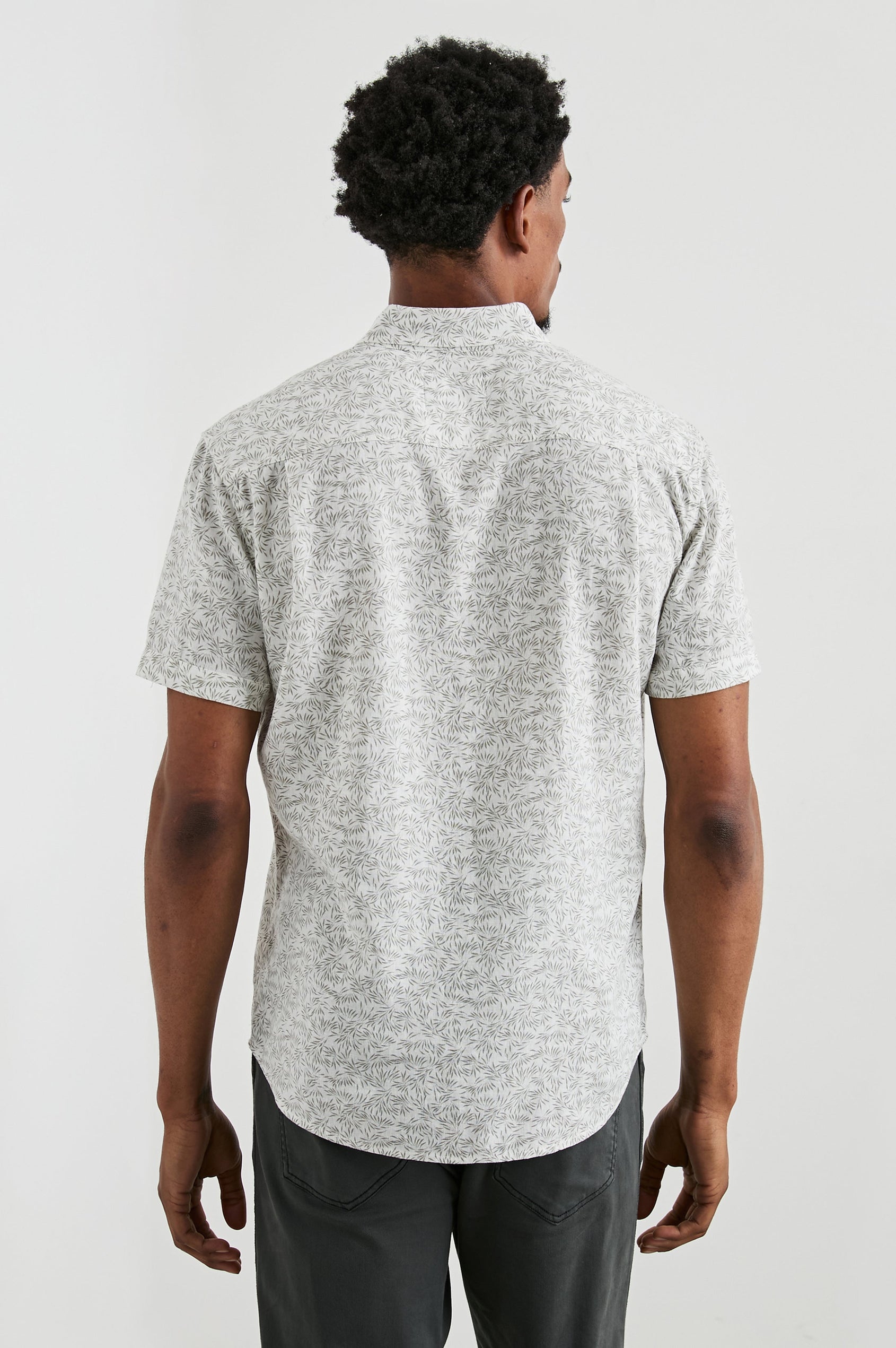 Carson Short Sleeve Button Up with a Chest Patch Pocket in Crop Circle White Colorway, Small Olive Leaves on White - Back View Featured on Model