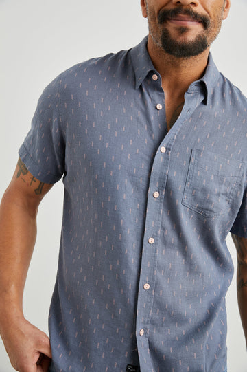 Carson Short Sleeve Button Up with a Chest Patch Pocket in Louis Leaf Slate Colorway, Small Tan and White Leaves on Slate- Front View Featured on Model
