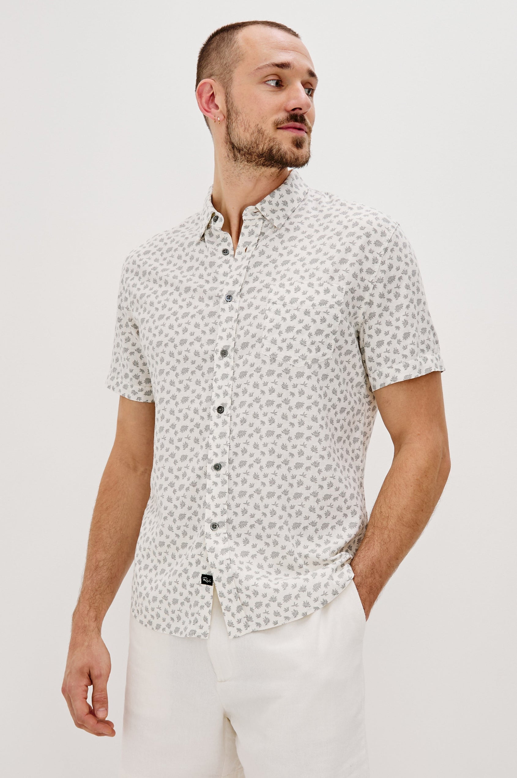 Carson Collared Button Front Shirt with Short Sleeves and a Chest Pocket in Nervous Leaf White Colorway. Front View Shown on Model.