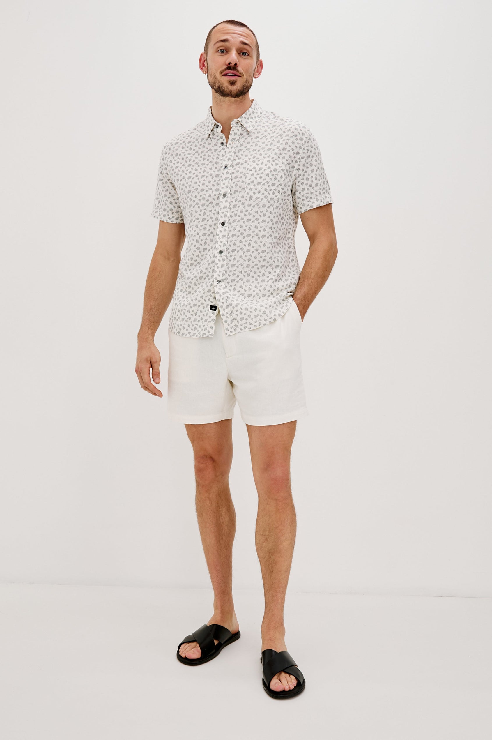 Carson Collared Button Front Shirt with Short Sleeves and a Chest Pocket in Nervous Leaf White Colorway. Full Body Front View Shown on Model.