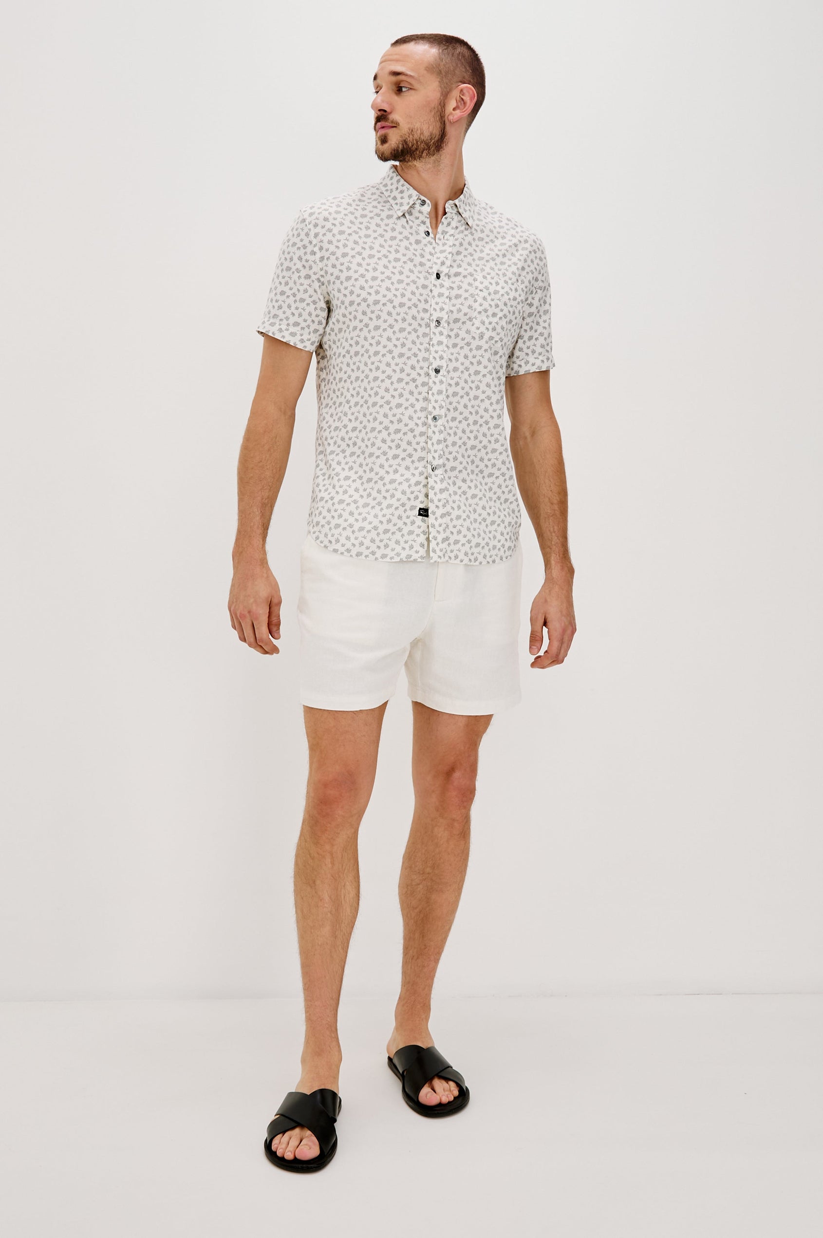 Carson Collared Button Front Shirt with Short Sleeves and a Chest Pocket in Nervous Leaf White Colorway. Full Body Front View Shown on Model.