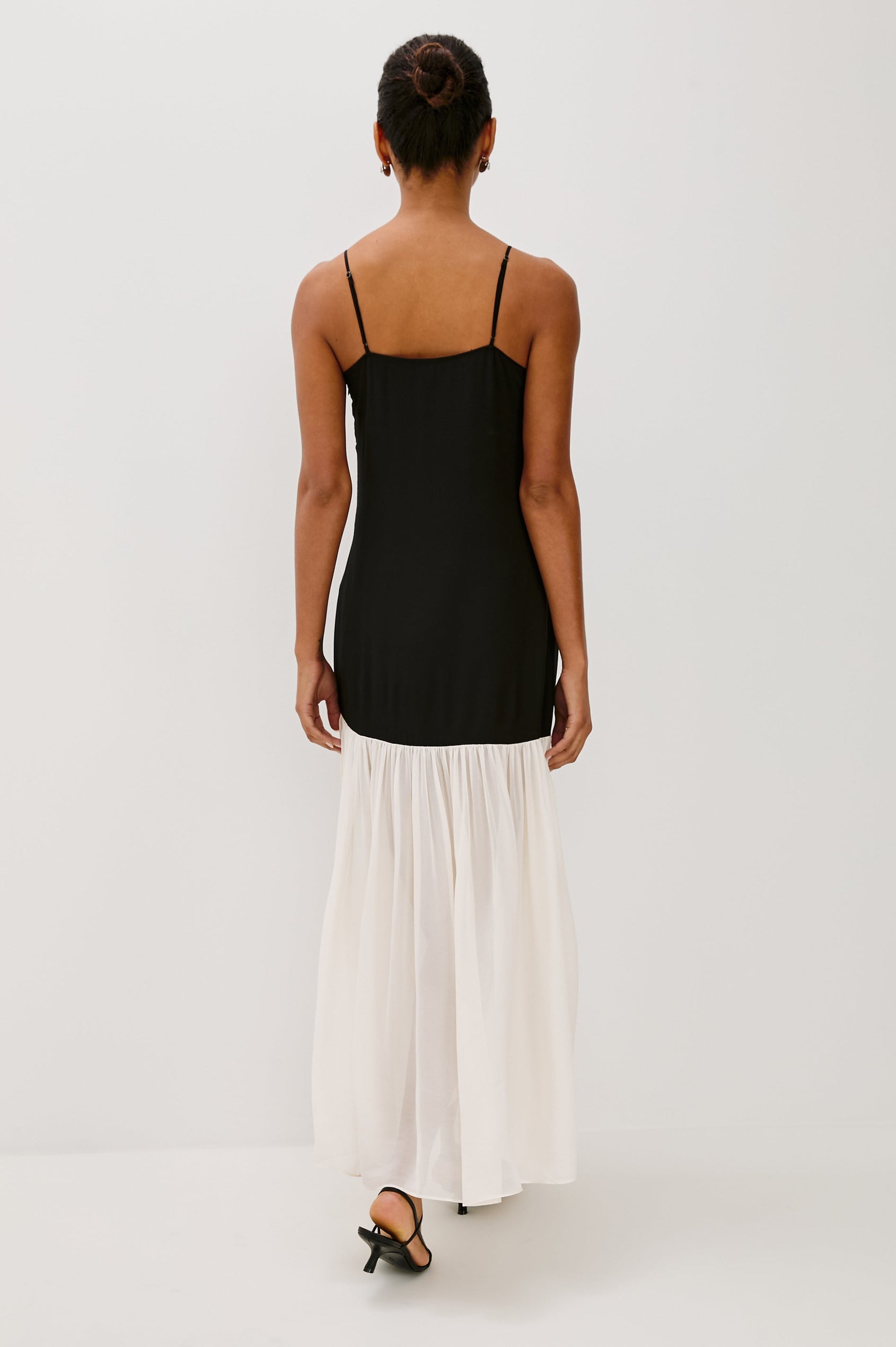 Chandra Maxi Tank Dress with Spaghetti Straps and a Contrast Semi Sheer Fabric Gathered Hem in Black Ivory Colorway - back view on model