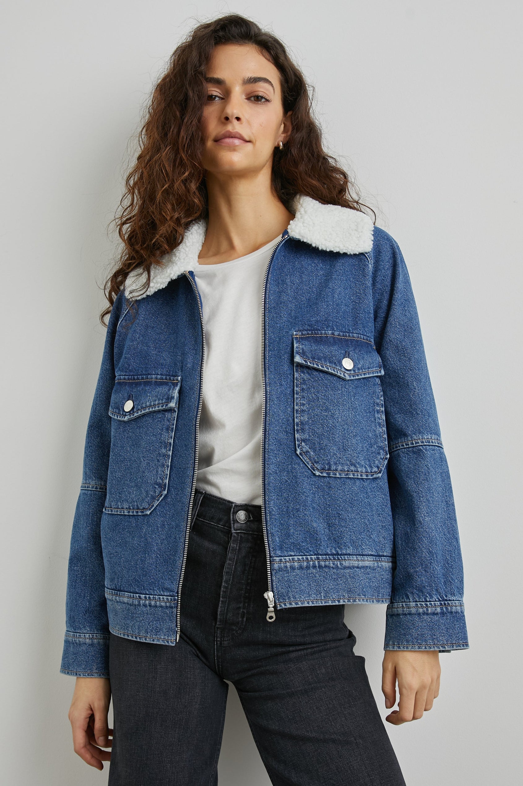 Cheyenne Zip-Up Denim Jacket with Two Buttoned Chest Flap Pockets, and Faux Shearling Collar in Indigo Sherpa Colorway - Front View Featured on Model 