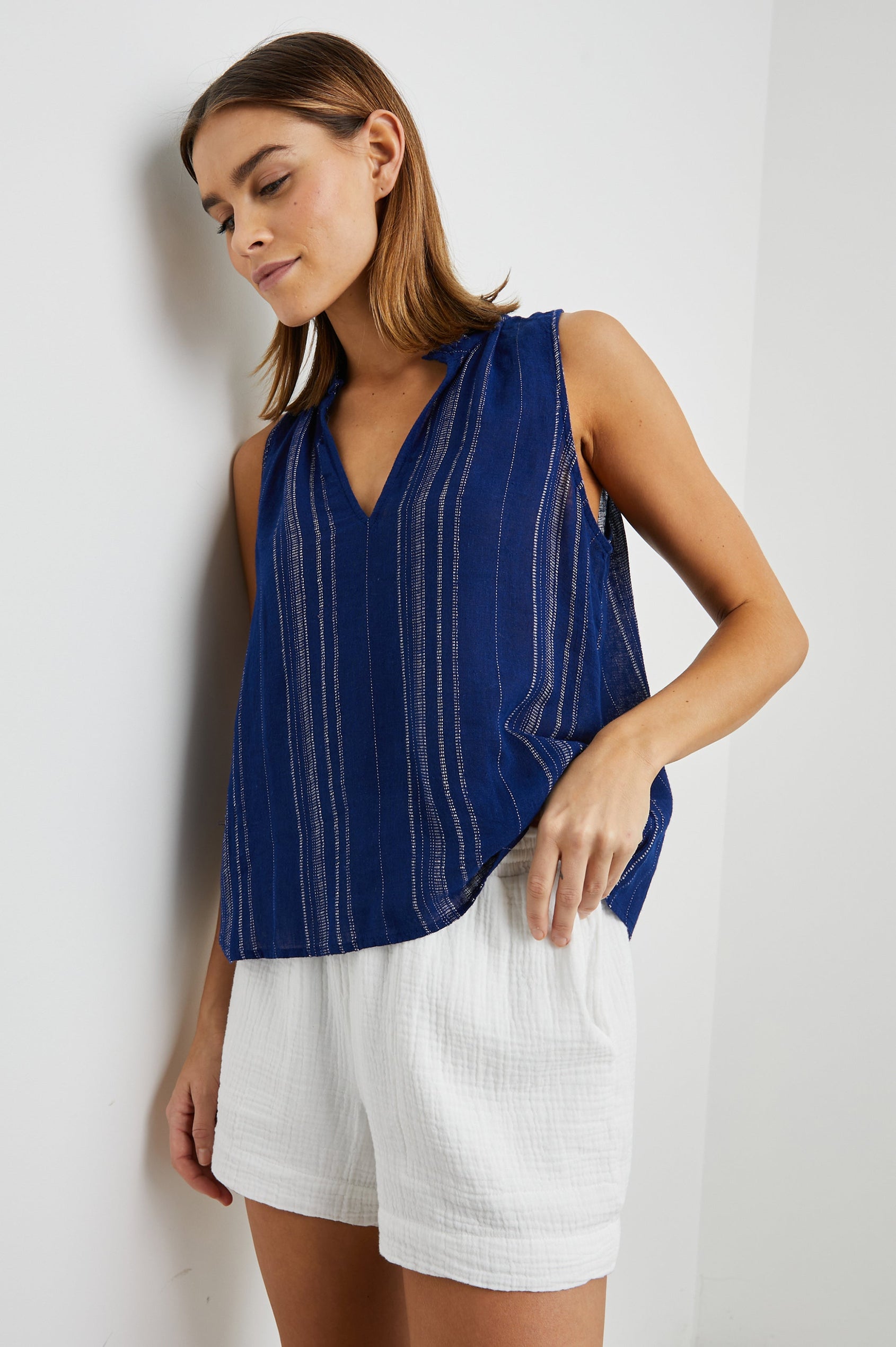 Christy Sleeveless Tank Top, with a V Neck and a Ruched Collar in Noja Stripe Colorway, Thin Vertical White Stripes on Blue - Front View Featured on Model