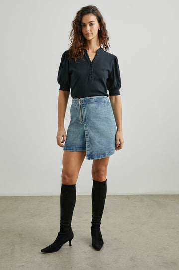 Cienega Denim Mini Skirt with an Asymmetrical Hem and a Wrap Appearance with a Diagonal Zipper in Geranium Colorway - Front Full Body View Featured on Model 