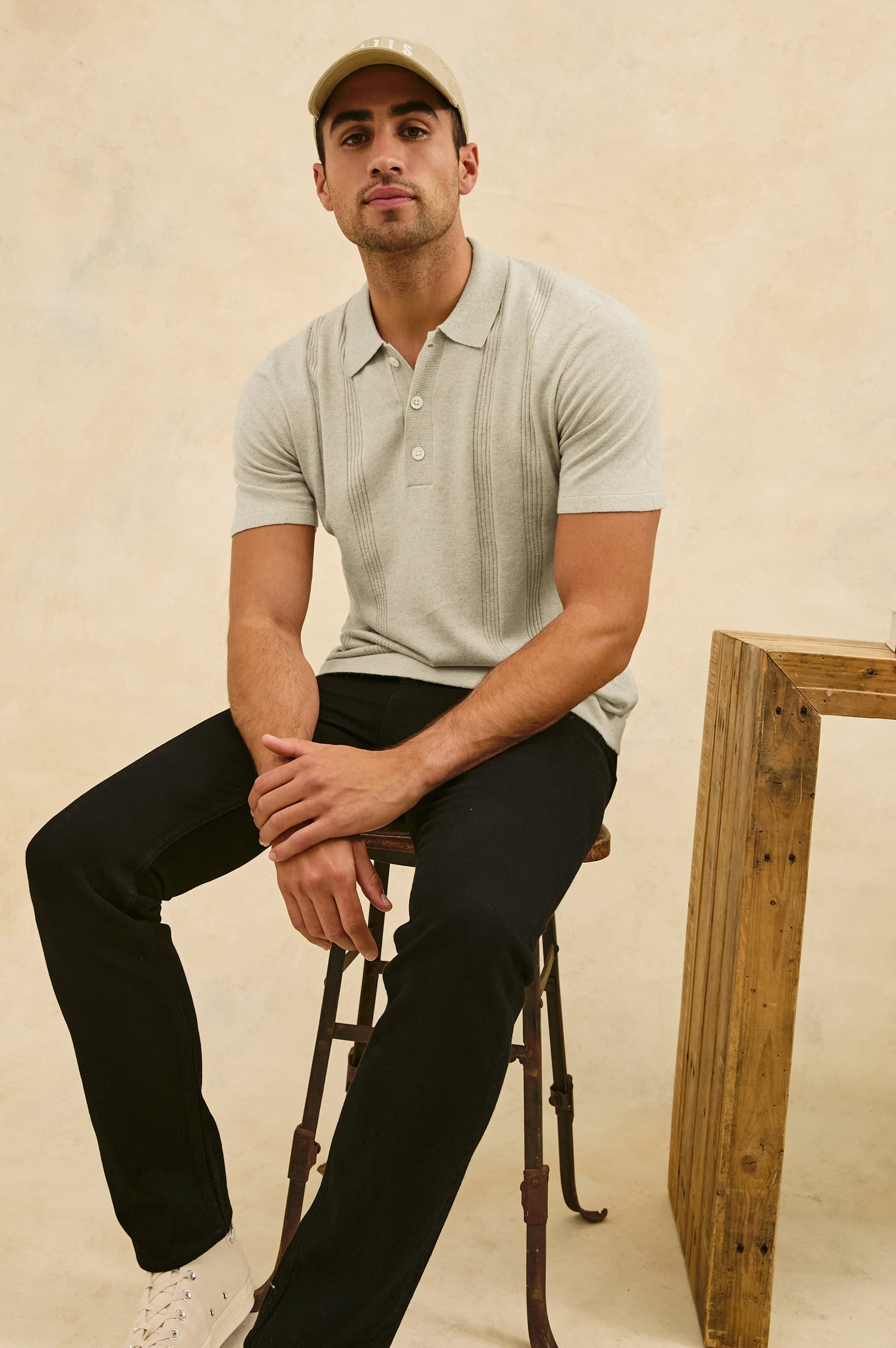 Cillian short sleeve cotton silk blend polo with three button placket and retro  front stripe details in Silversand - stylized front view on model, sitting in chair