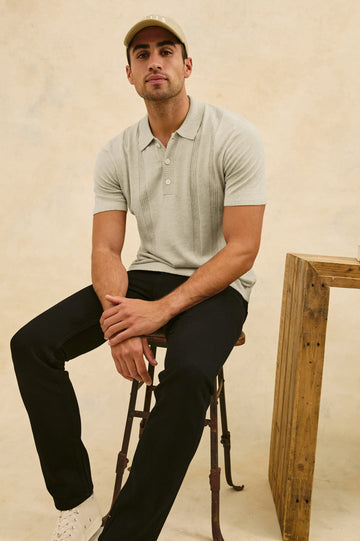 Cillian short sleeve cotton silk blend polo with three button placket and retro  front stripe details in Silversand - stylized front view on model, sitting in chair