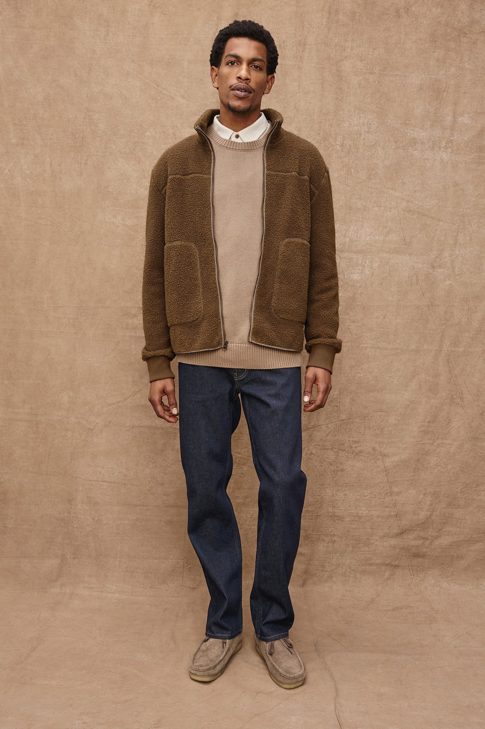 The Clark is a zip front brushed back polar fleece and details include contrast stitching, two zipper pockets, and contrast  grey ribbed cuffs in Lichen colorway. Front full body view featured on model.