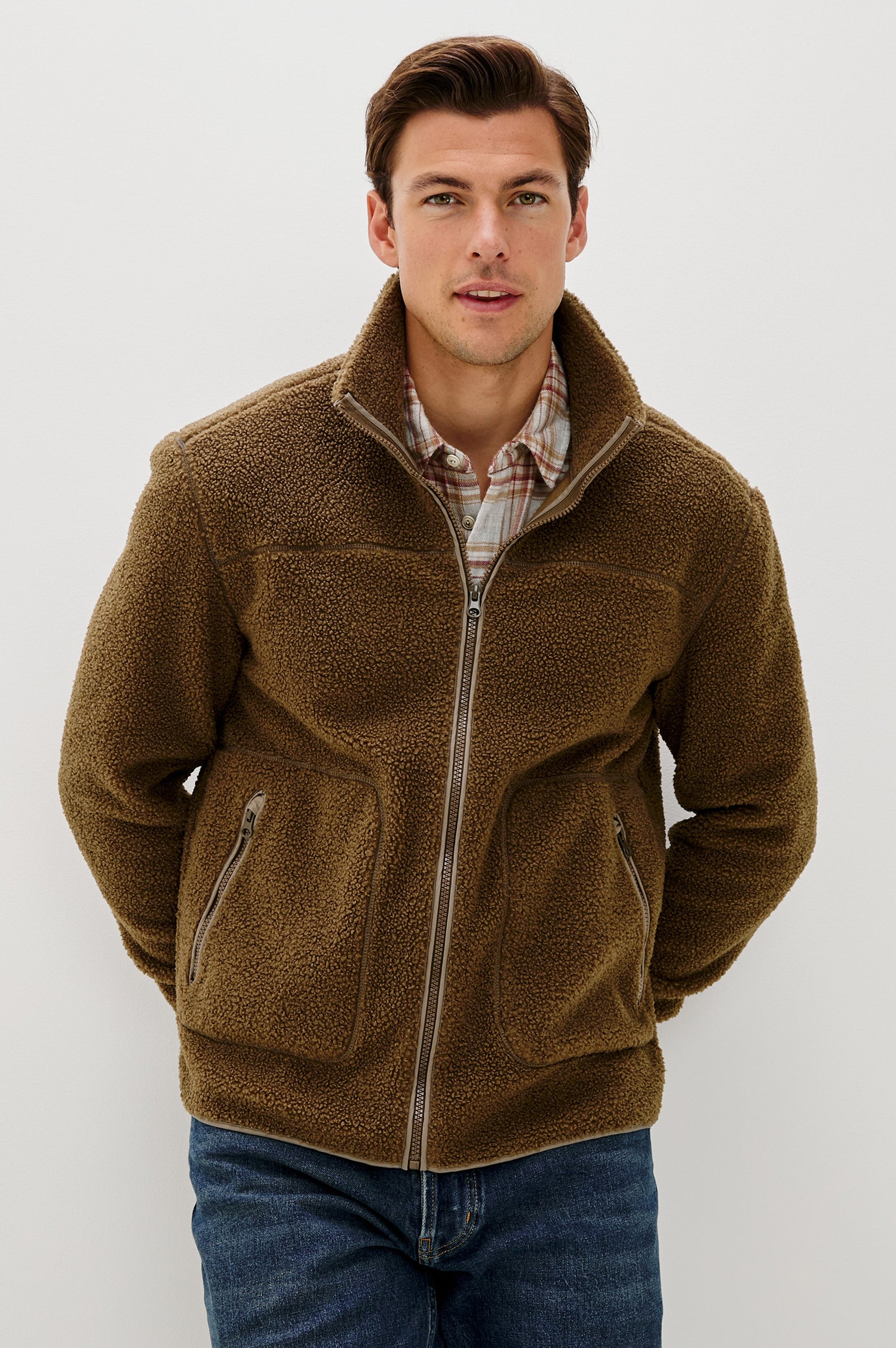 The Clark is a zip front brushed back polar fleece and details include contrast stitching, two zipper pockets, and contrast  grey ribbed cuffs in Lichen colorway. Front view featured on model.