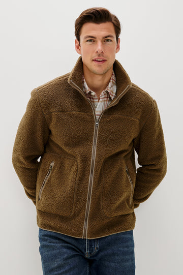 The Clark is a zip front brushed back polar fleece and details include contrast stitching, two zipper pockets, and contrast  grey ribbed cuffs in Lichen colorway. Front view featured on model.