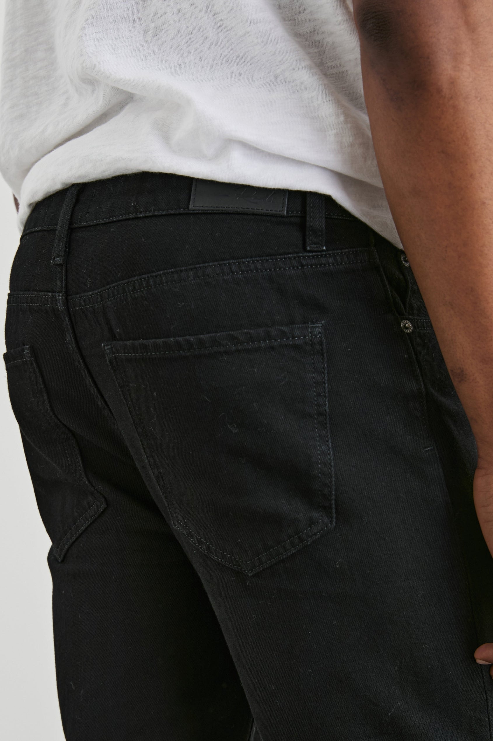 Clayton Slim Straight Jeans with Belt Loops, Two Front Pockets plus a Coin Pocket and Two Back Patch Pockets in Dark Black Colorway - Back View Featured on Model