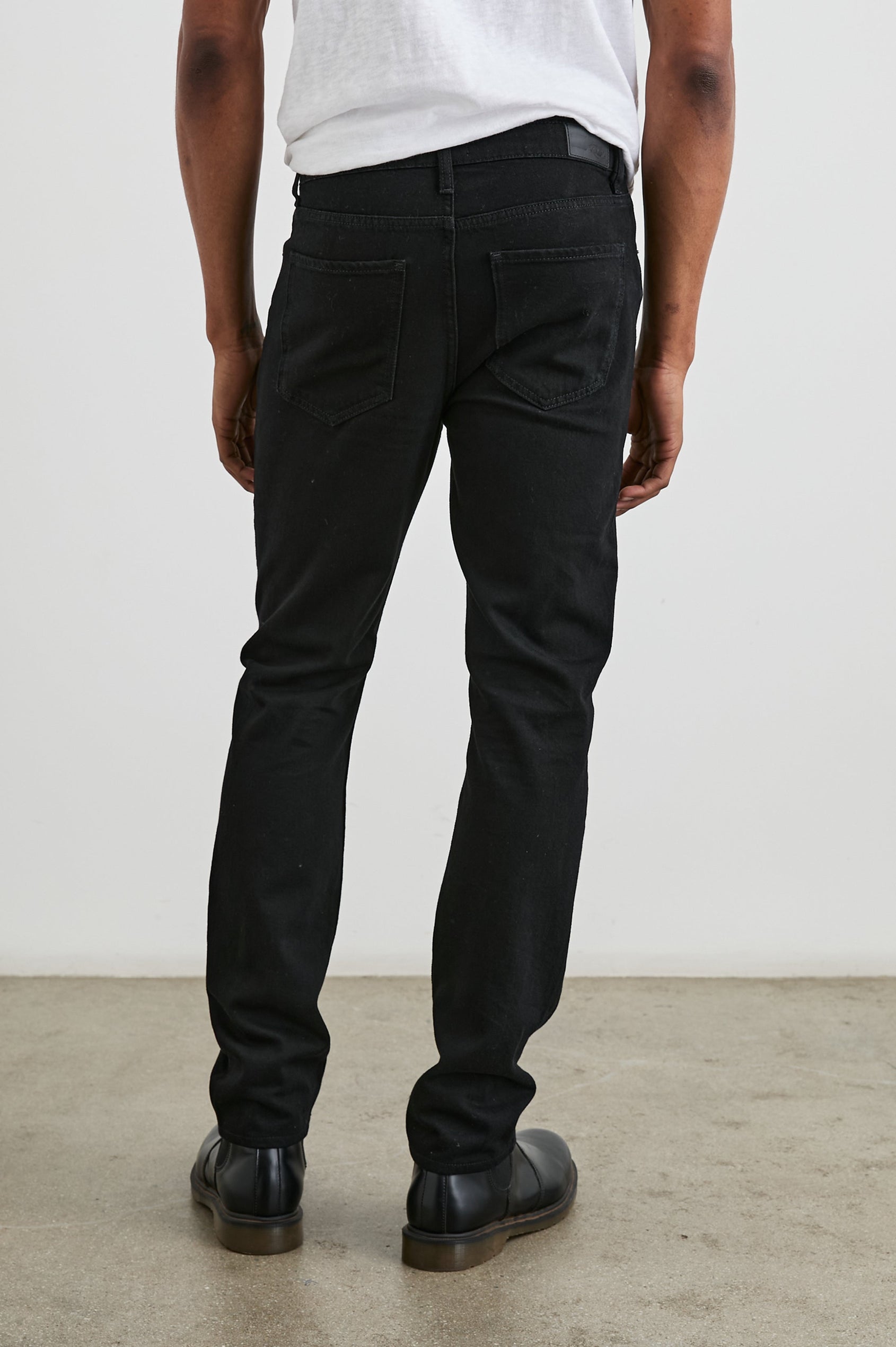 Clayton Slim Straight Jeans with Belt Loops, Two Front Pockets plus a Coin Pocket and Two Back Patch Pockets in Dark Black Colorway - Back View Featured on Model