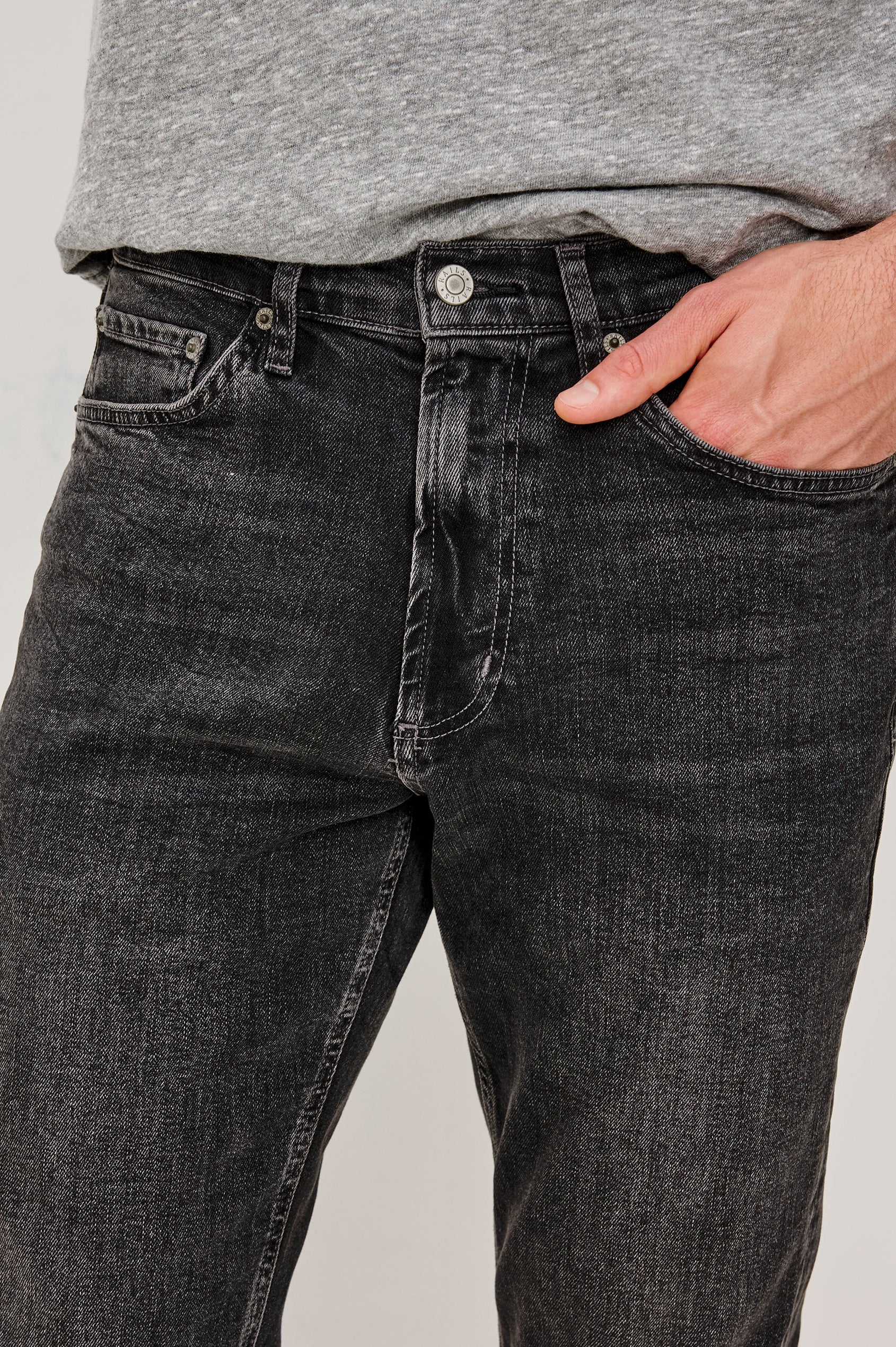 Clayton Slim Straight is a Classic 5-Pocket Jean in Faded Onyx Colorway, a Washed Black. Front Detail View Featured on Model.