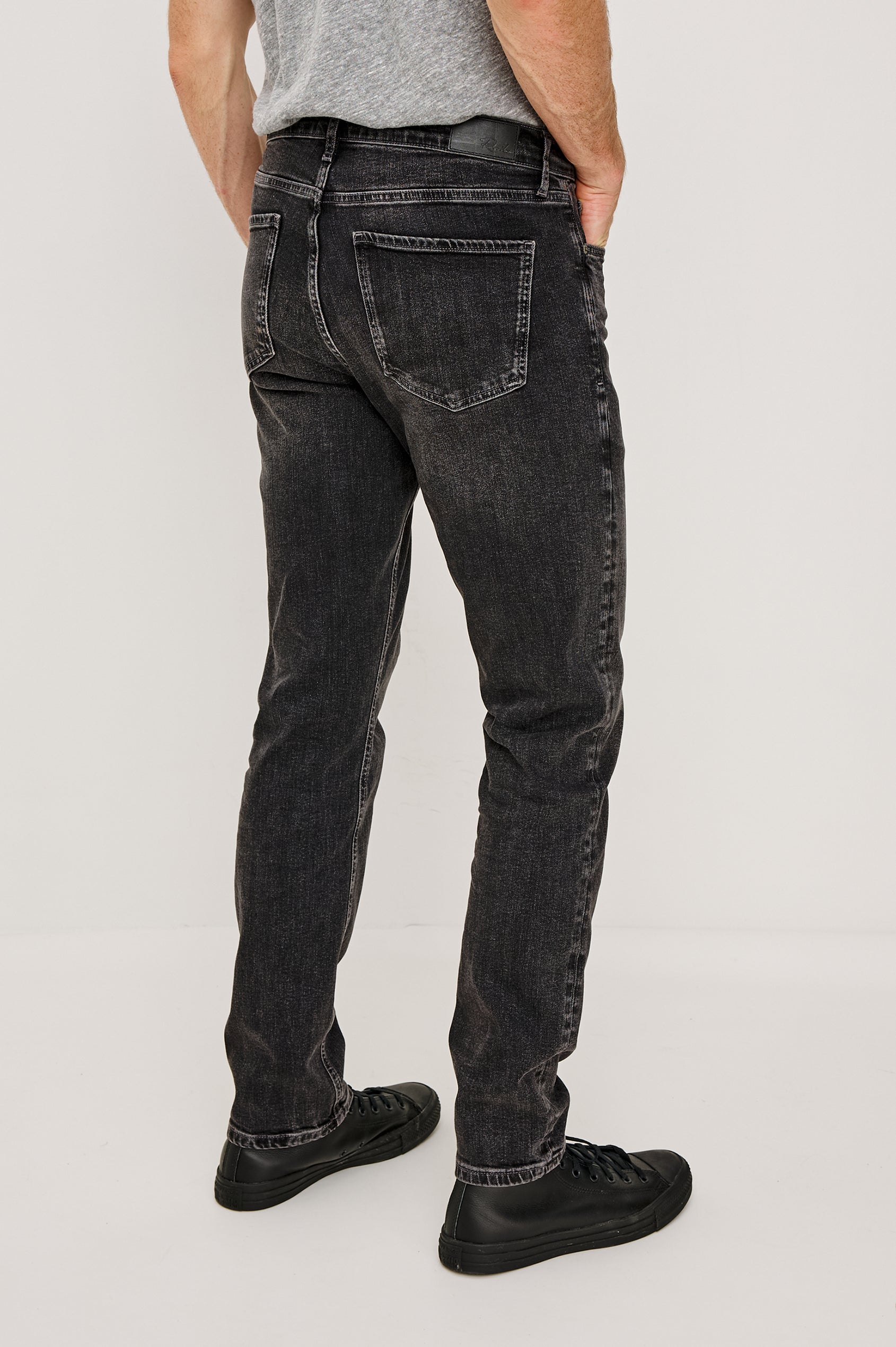 Clayton Slim Straight is a Classic 5-Pocket Jean in Faded Onyx Colorway, a Washed Black. Back View Featured on Model.