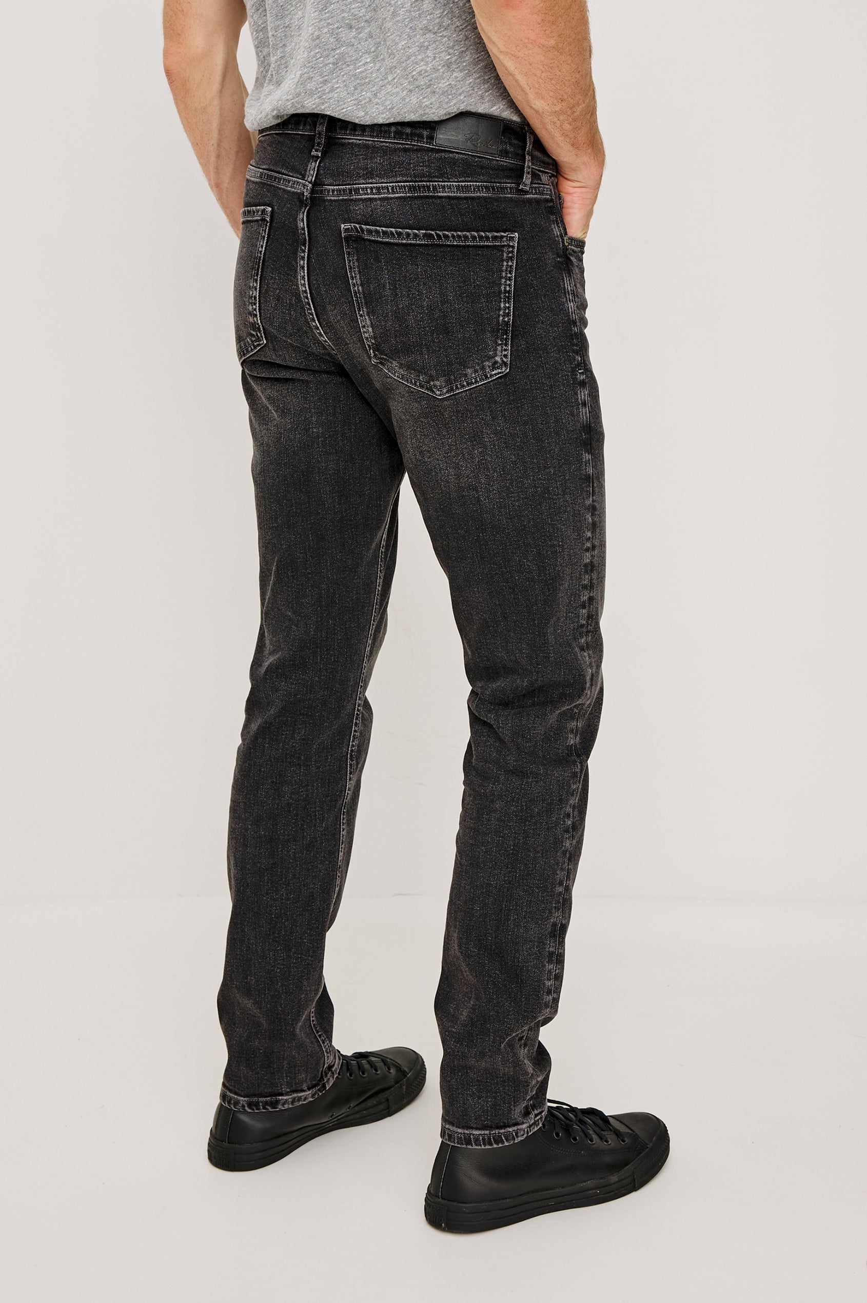 Clayton Slim Straight is a Classic 5-Pocket Jean in Faded Onyx Colorway, a Washed Black. Back View Featured on Model.