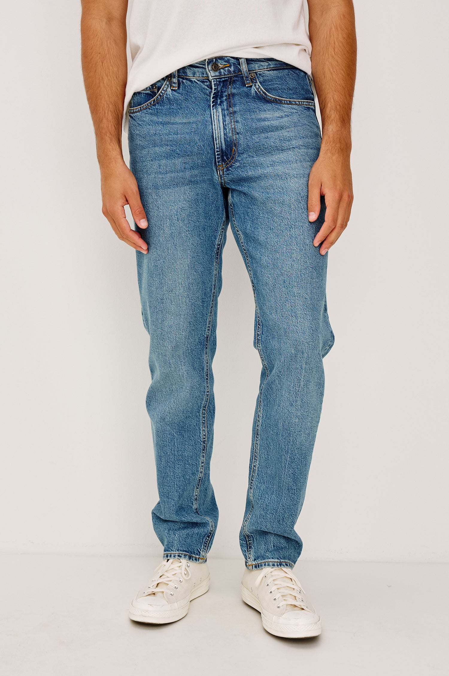 Clayton Slim Straight is a Classic 5-Pocket Jean in Heritage Indigo Colorway, a Medium Blue Wash. Front View Featured on Model.