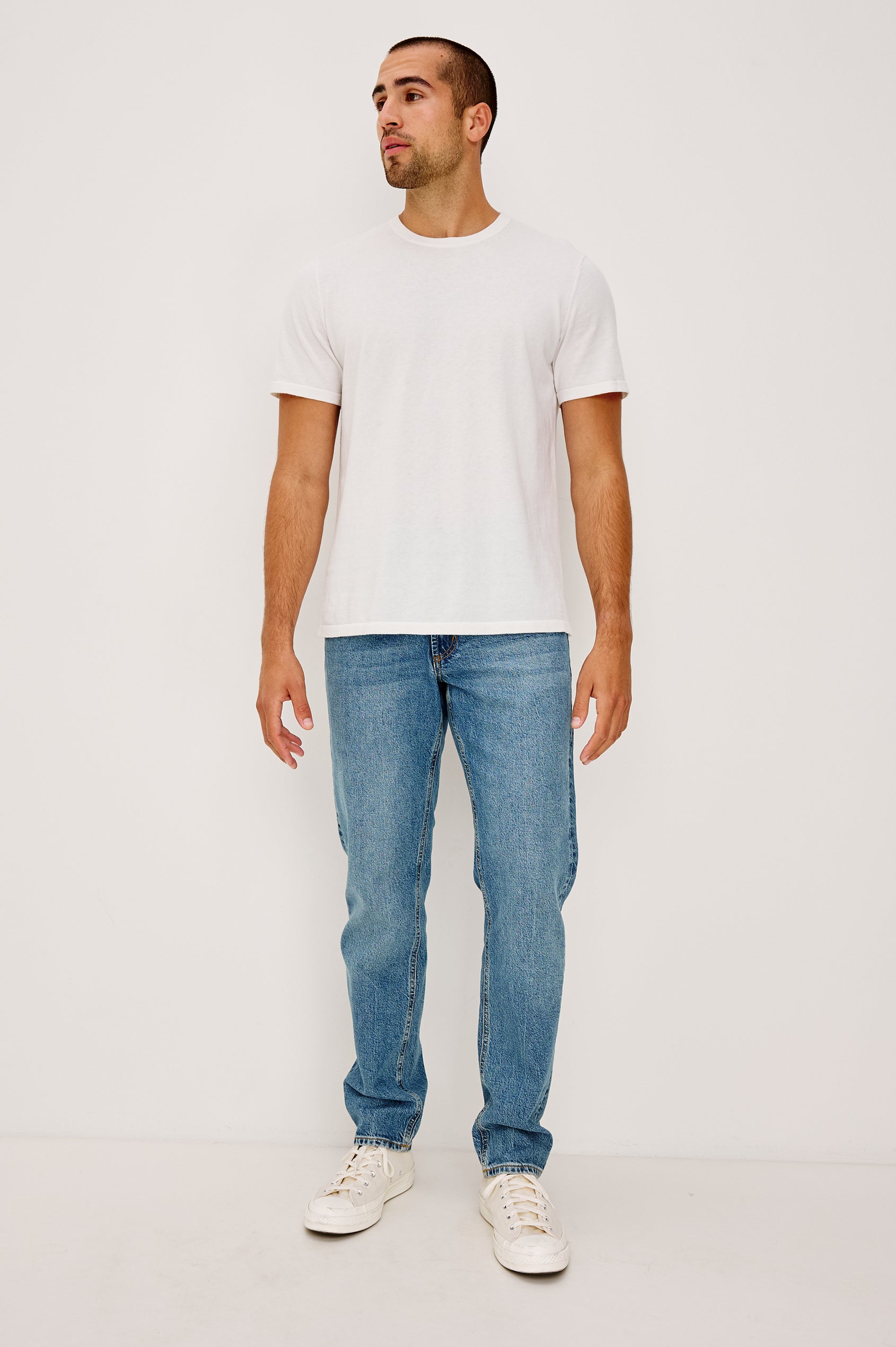 Clayton Slim Straight Jean With 5-Pocket Styling, Belt Loops, and Front Zip-Fly in Heritage Indigo Colorway - Lower Body Front View Featured on Model