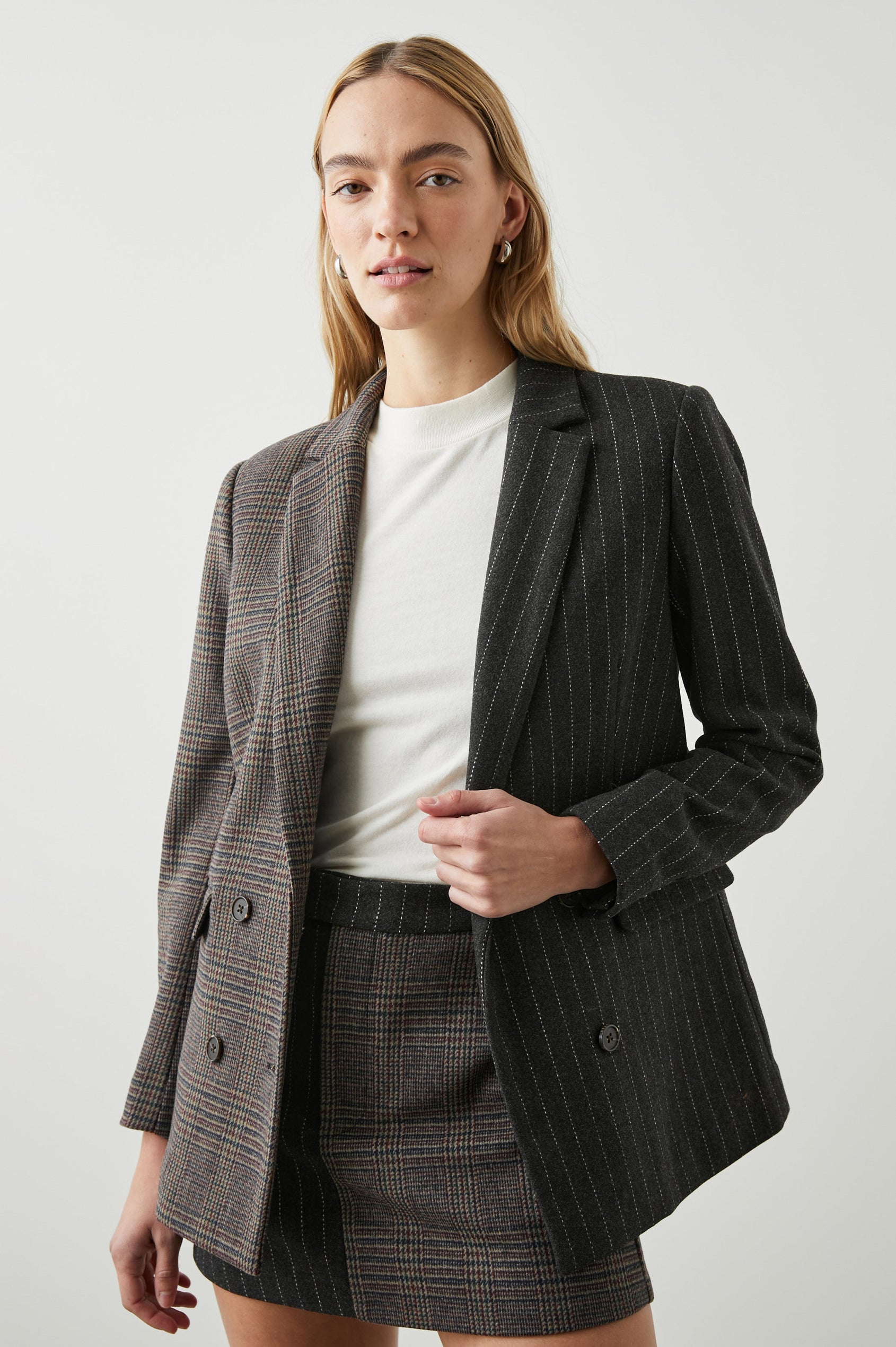 Cody Double-Breasted Blazer with Two Button Closure, Two Front Flap Pockets, and Four-Button Cuffs in Pinstripe Plaid Mix Colorway, the Right Half is a Plaid in Brown, Blue and Red, the left half is White pinstripe on Black - Front View Featured on Model