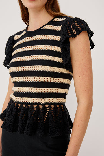 Coen Top in Cotton Blend Crochet With Crew Neckline Eyelet Detailing Flutter Sleeves Pepplum Hem and Back Keyhole With Adjustable Ties in Black Oat Stripe Colorway - Upper Body Close Up View Featured on Model