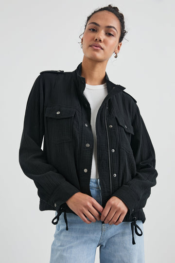 Collins Jacket with Zip and Snap Closure, Two Chest Snap Flap Pockets, Toggle Drawstring Hem, Snap Shoulder Straps and a Breathable Back Flap in Gauze Black Colorway - Front View Featured on Model