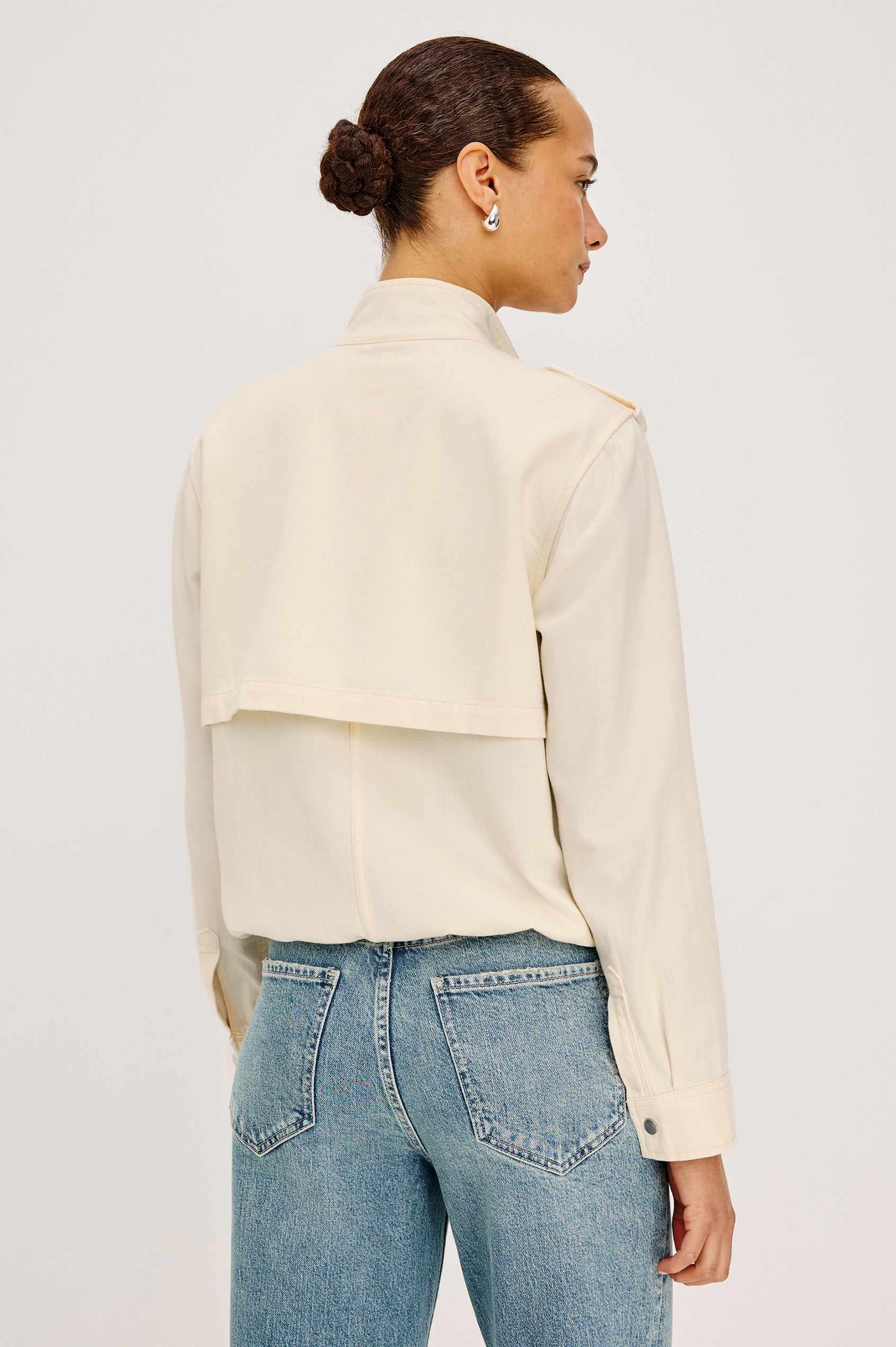 Collins Miitary Inspired Jacket With Shoulder Epaluettes, Stand Collar, Front Snap Buttons, Double Chest Pockets, Long Sleeves in Ivory Colorway - Upper Body Back View Featuered on Model
