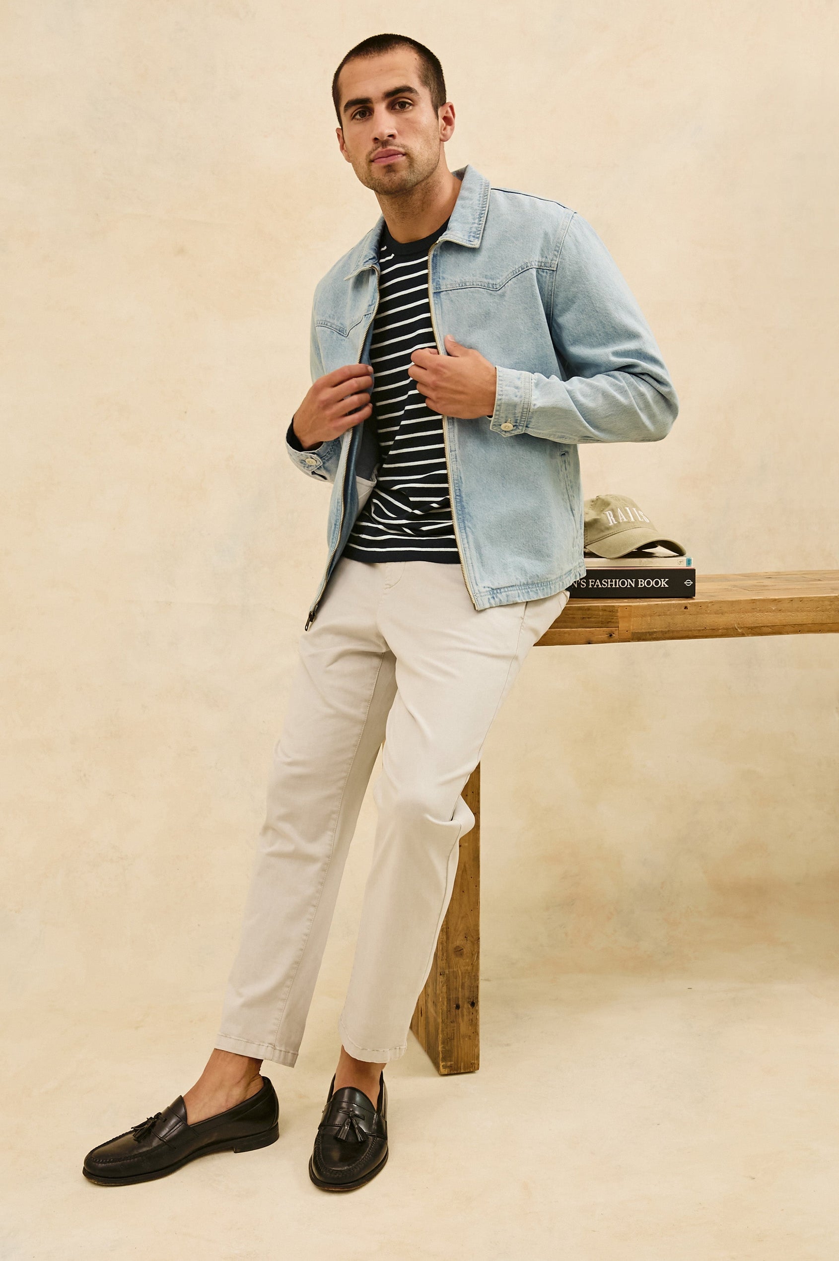 Cooke western style zip-up  jacket with contrast stitching details in Light Wash - full body front view on model, stylized leaning on desk