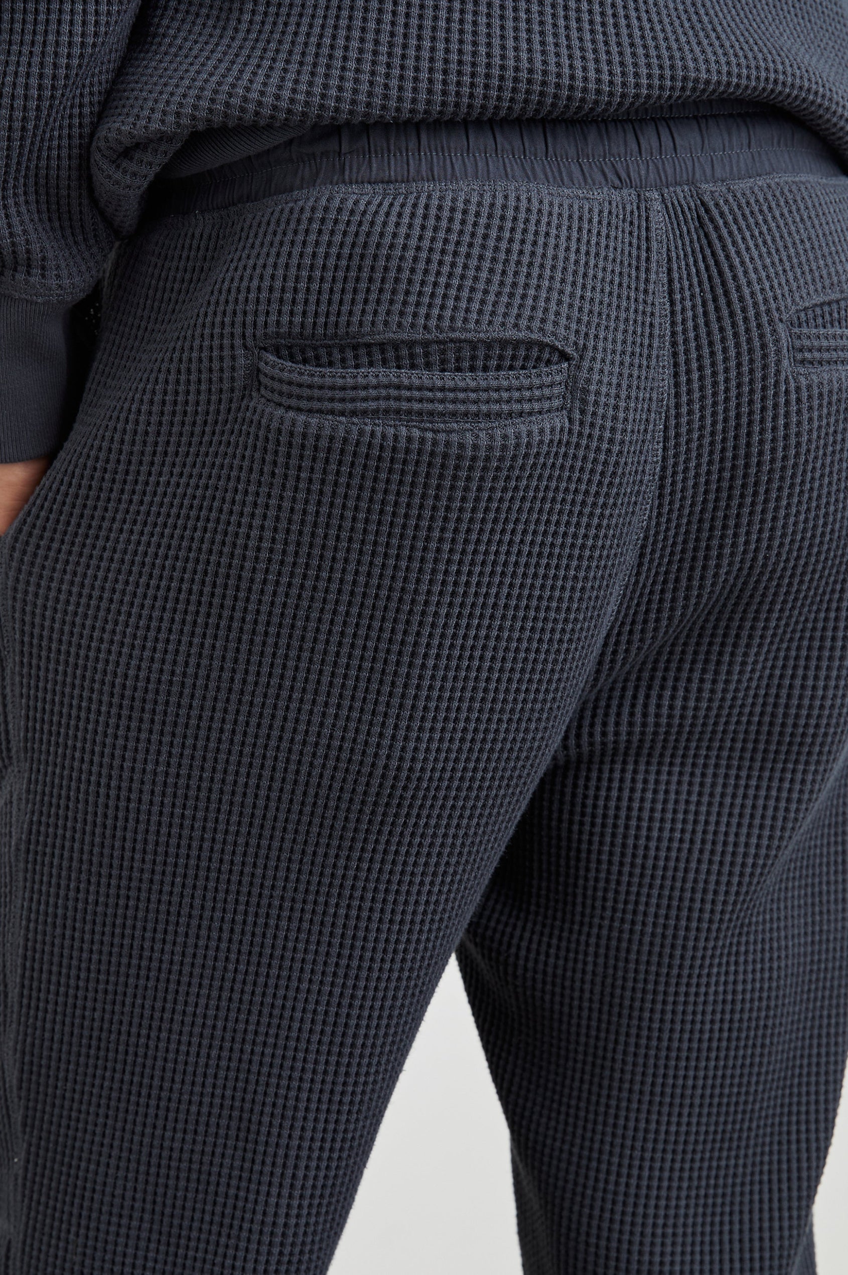 Cooper Waffle Thermal Pants with an Elastic Drawstring Waist, Two Teardrop Front Pockets, Two Back Welt Pockets, Reinforced Knee Patches and Elastic Cuffs in Ink Colorway - Back View Featured on Model