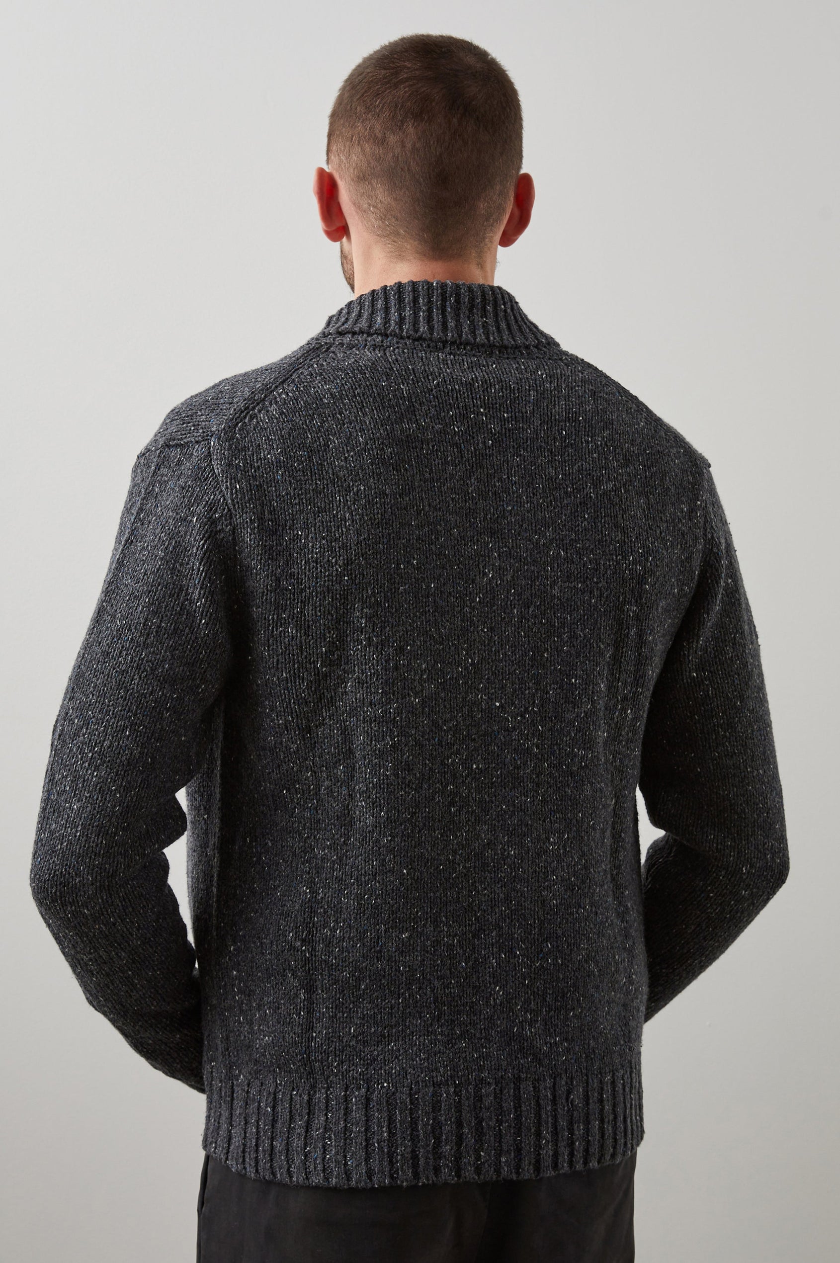 Corden Long-Sleeve Cardigan with Button Closure, a Shawl Collar and Ribbed Trim in Constellation Colorway, White and Blue Speckles on Dark Grey - Back View Featured on Model