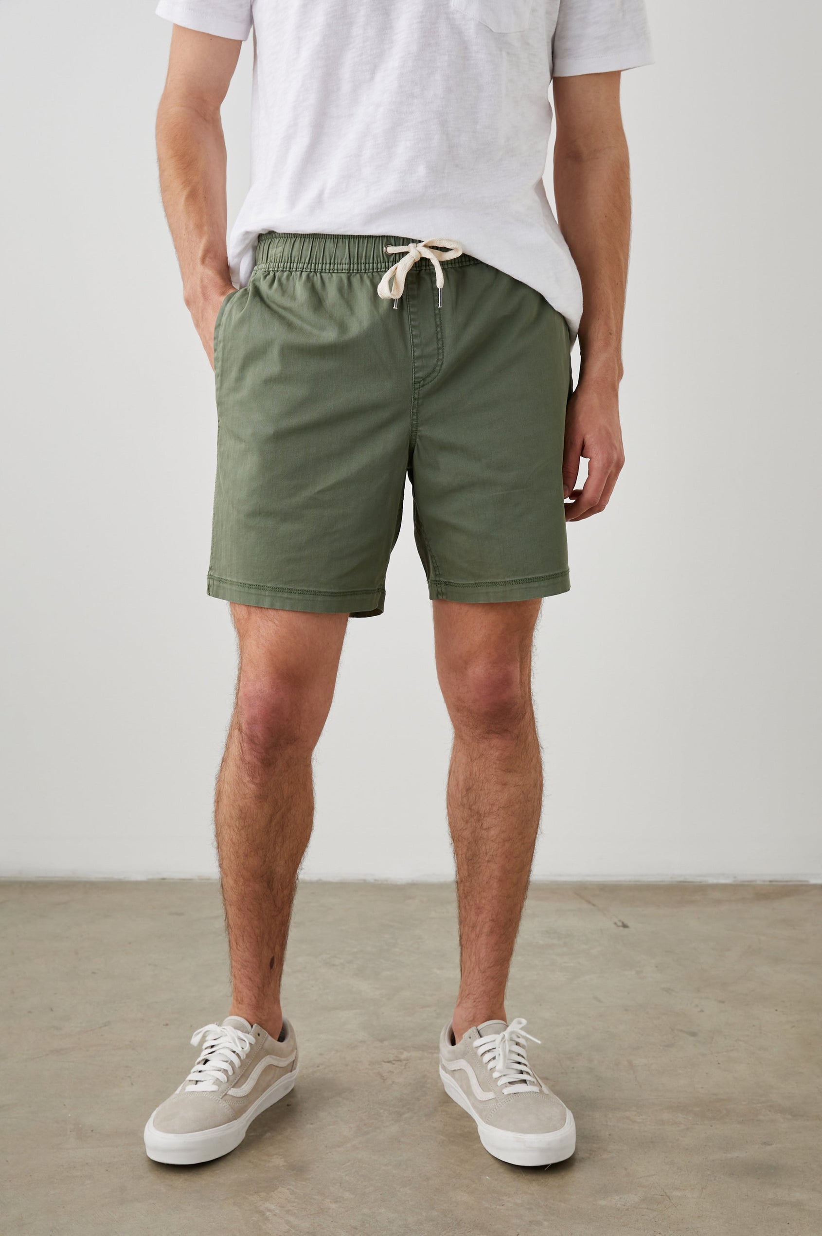 Cruz Shorts with a Drawstring Waist, Two Front Pockets, Two Back Button Flap Pockets in Spring Olive Colorway - Front View Featured on Model 