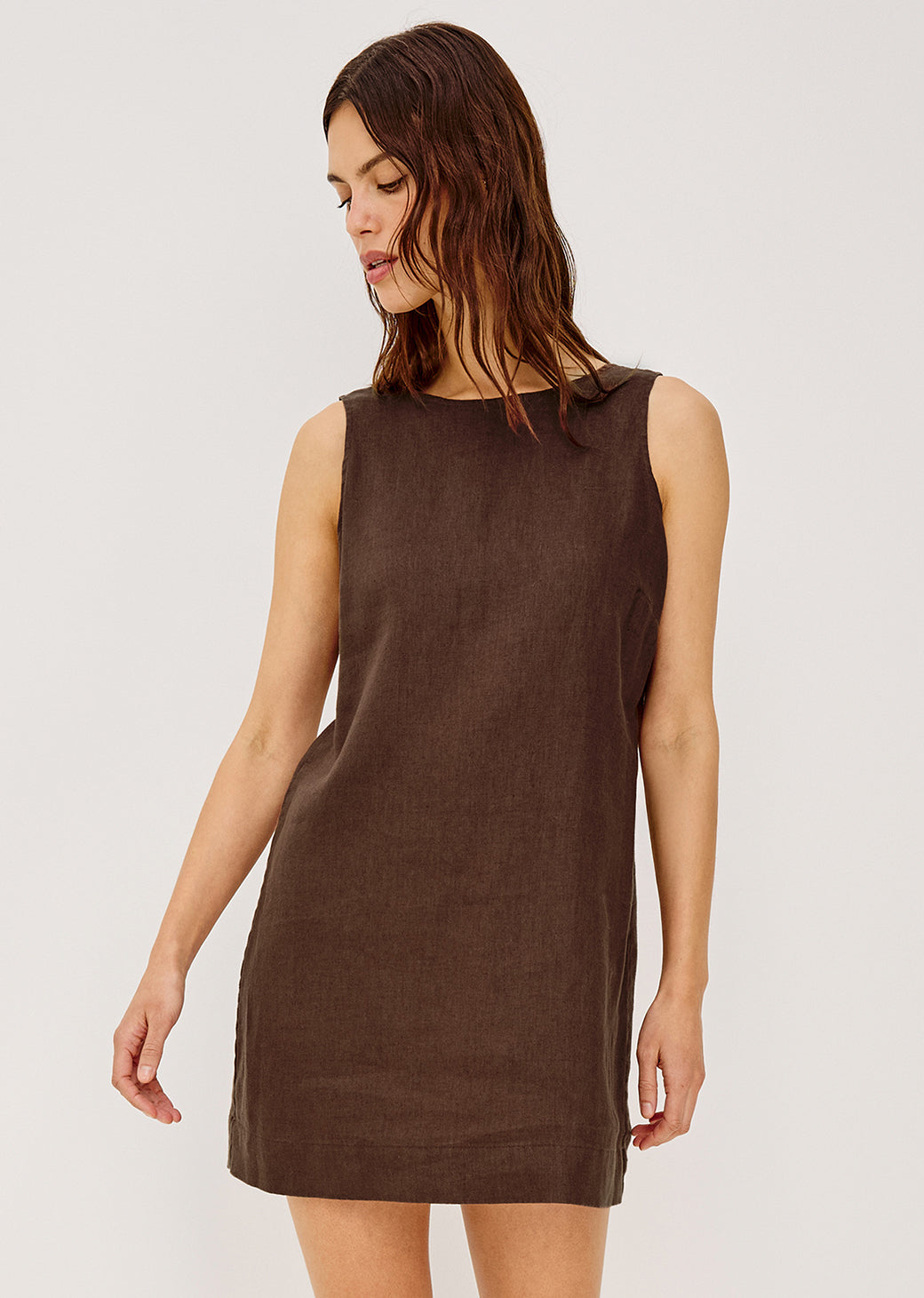 Woman wearing a brown sleeveless dress on a white background