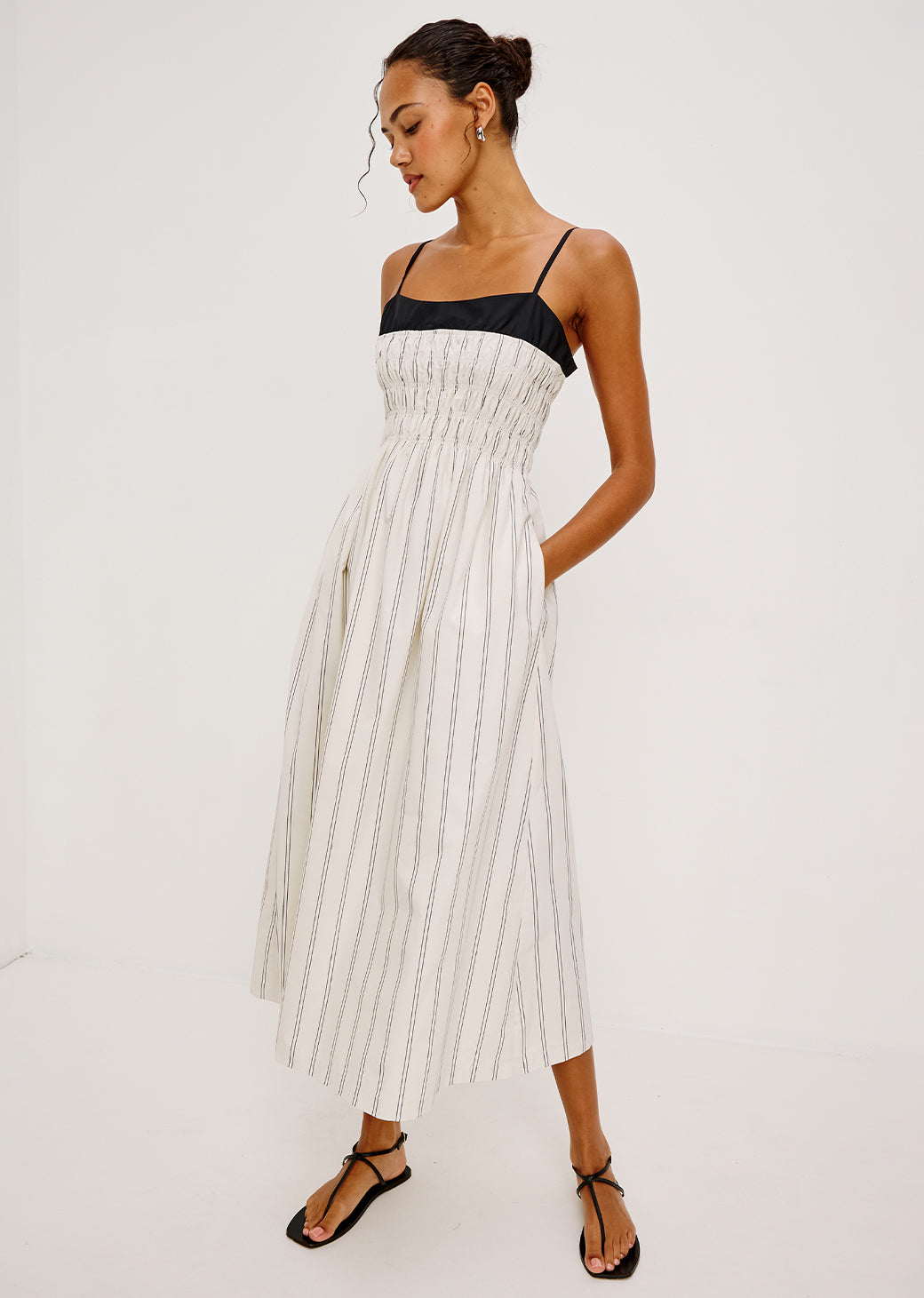 Woman wearing a white and black striped dress on a white background