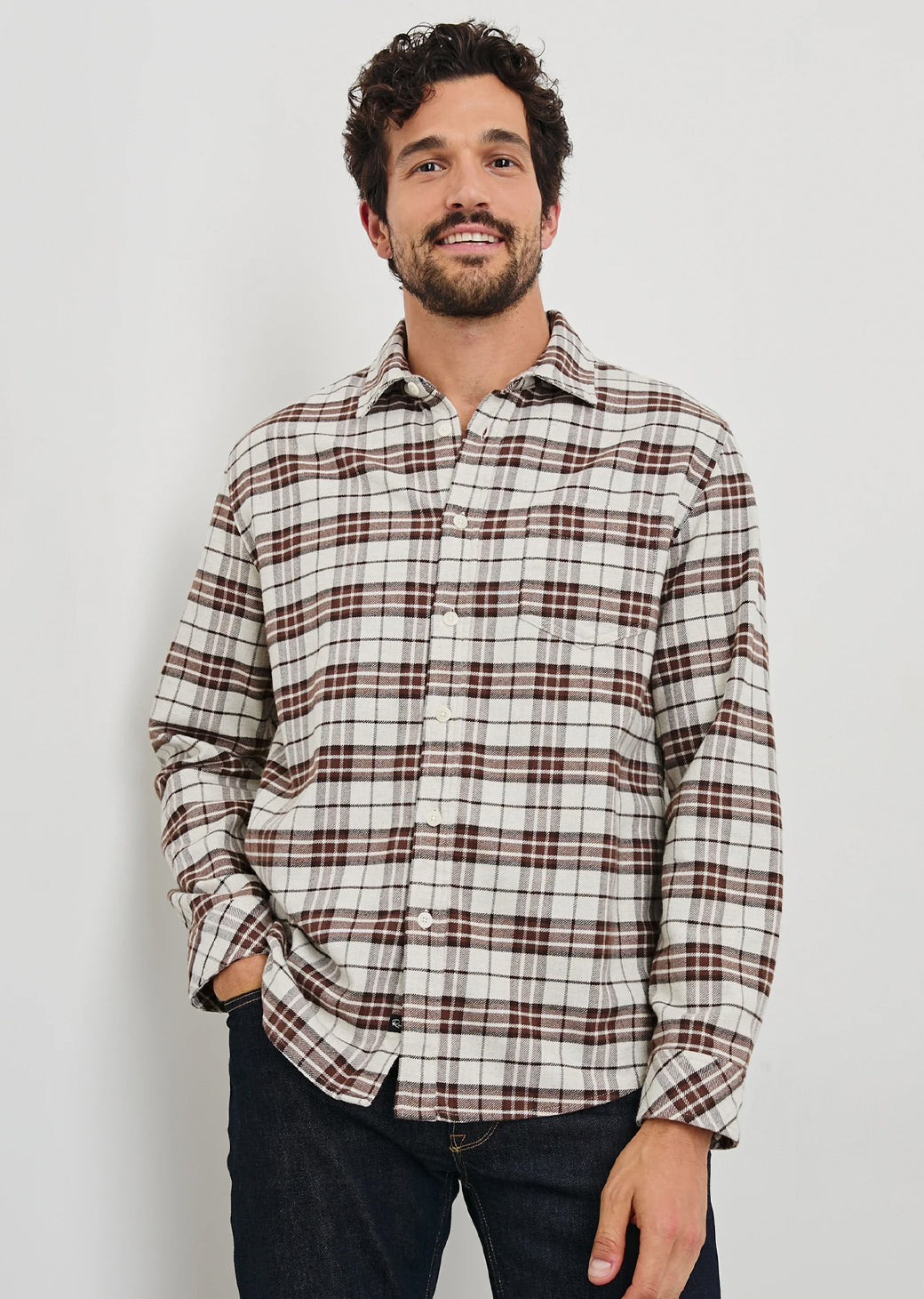 Man wearing a plaid shirt against a plain background