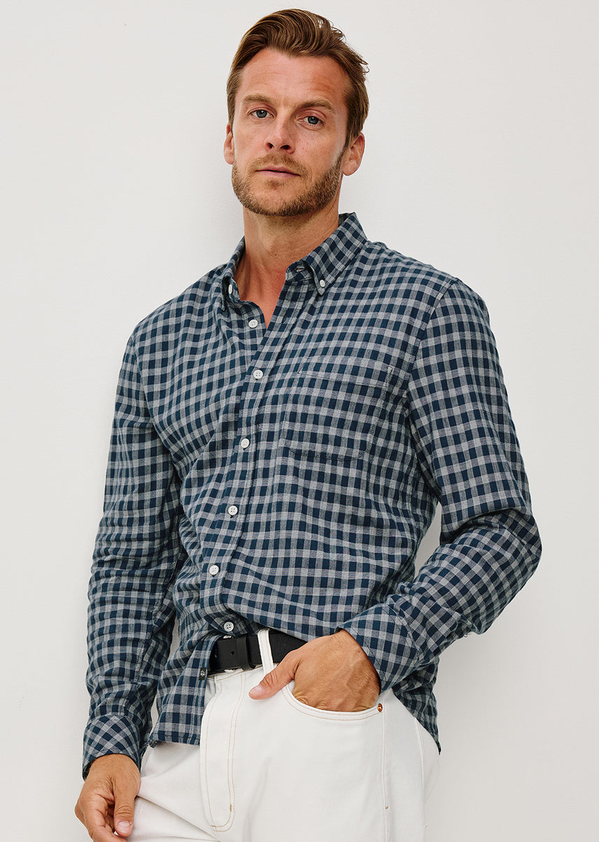 Man wearing a navy plaid shirt against a white background