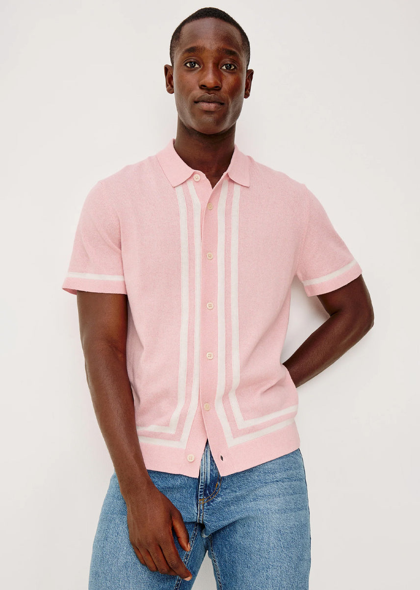 Man wearing a pink button-down shirt with blue jeans