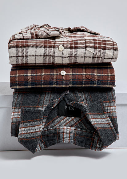 MULTIPLE PLAID SHIRTS FOLDED AND STACKED ON TOP OF EACH OTHER