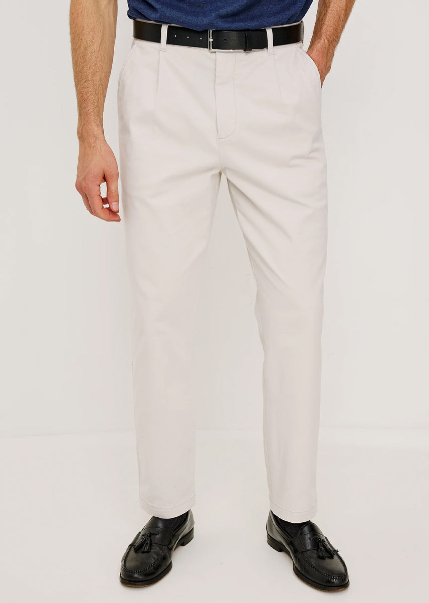 Man wearing white dress pants with a plain background