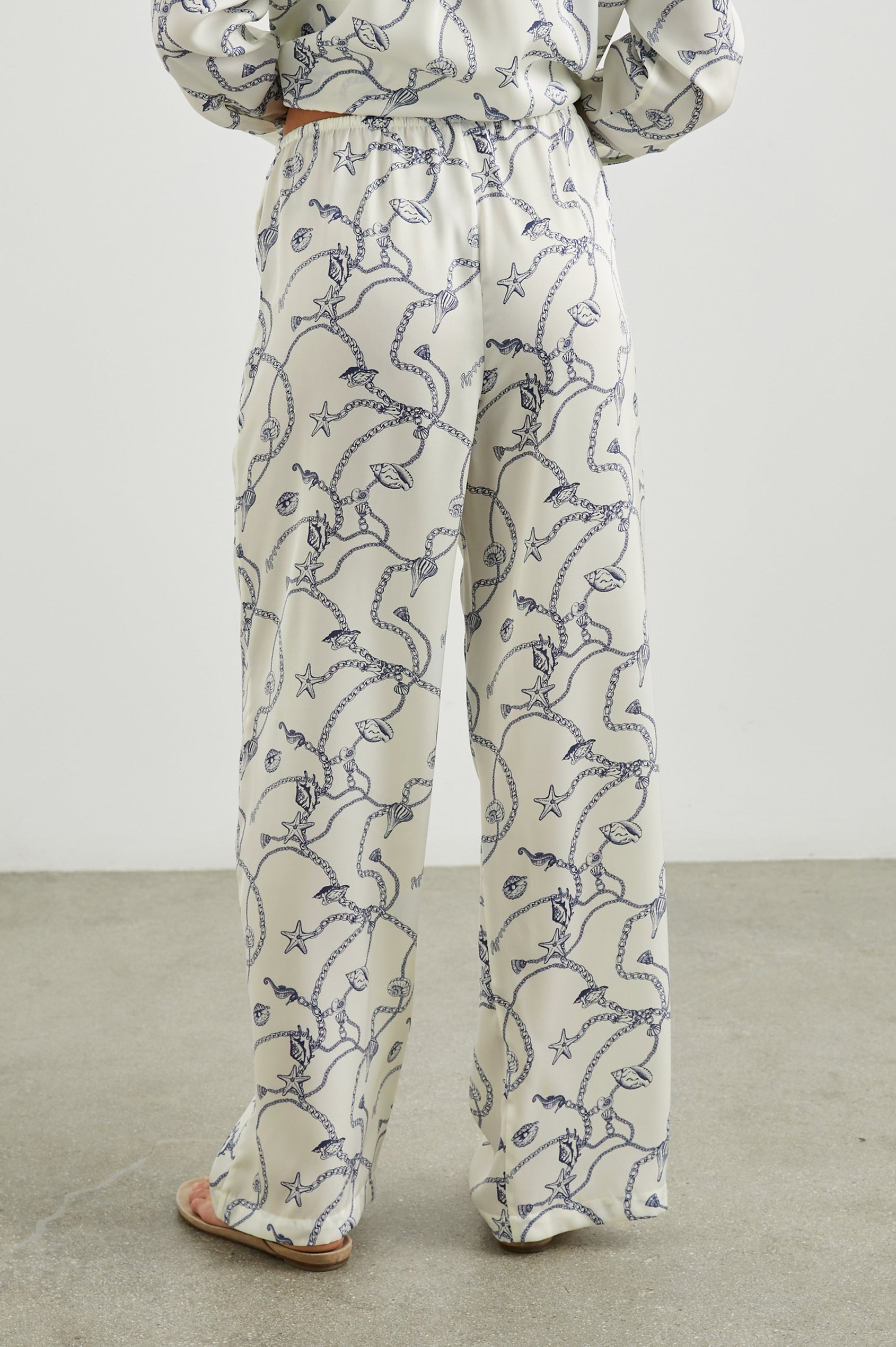 Damini Pants with a Drawstring Waist and Two Front Pockets in Nautical Chain Colorway, with a blue Nautical pattern on white - Back View Featured on Model