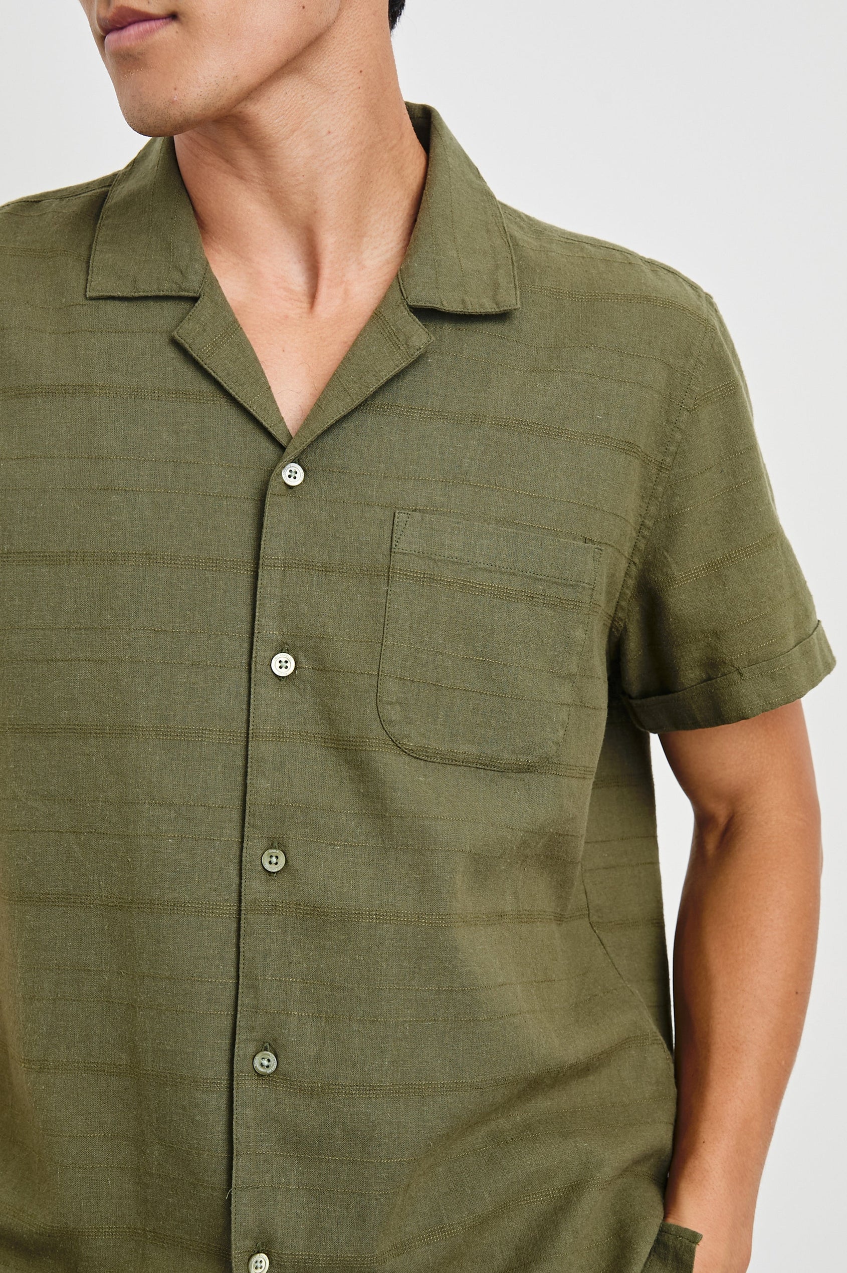 Davis Short Sleeve Button Up with a Chest Patch Pocket, Rolled Cuffs and Textured Horizontal Stripes in True Olive Colorway - Front View Featured on Model