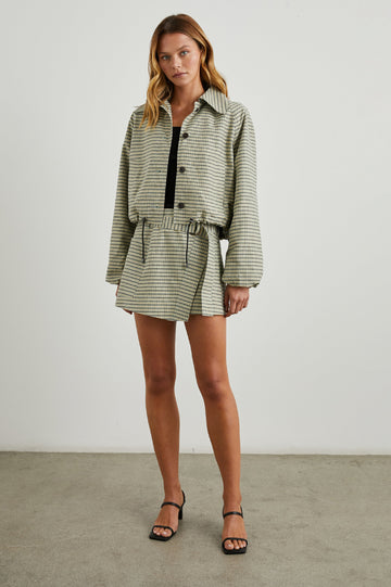 Deanna Mini Wrap Skirt with Fabric Belt and Two Side Pockets in Sage Mini Check Colorway, olive, yellow and sage plaid - Front Full Body View Featured on Model