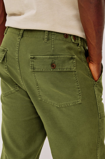 Decker Relaxed Straight Leg Workwear Pant in Stretch Cotton With Lived-In Wash, Zip Fly, and Side and Back Buttoned-Flap Pockets in Olive Colorway - Lower Body Close Up Back View Featured on Model