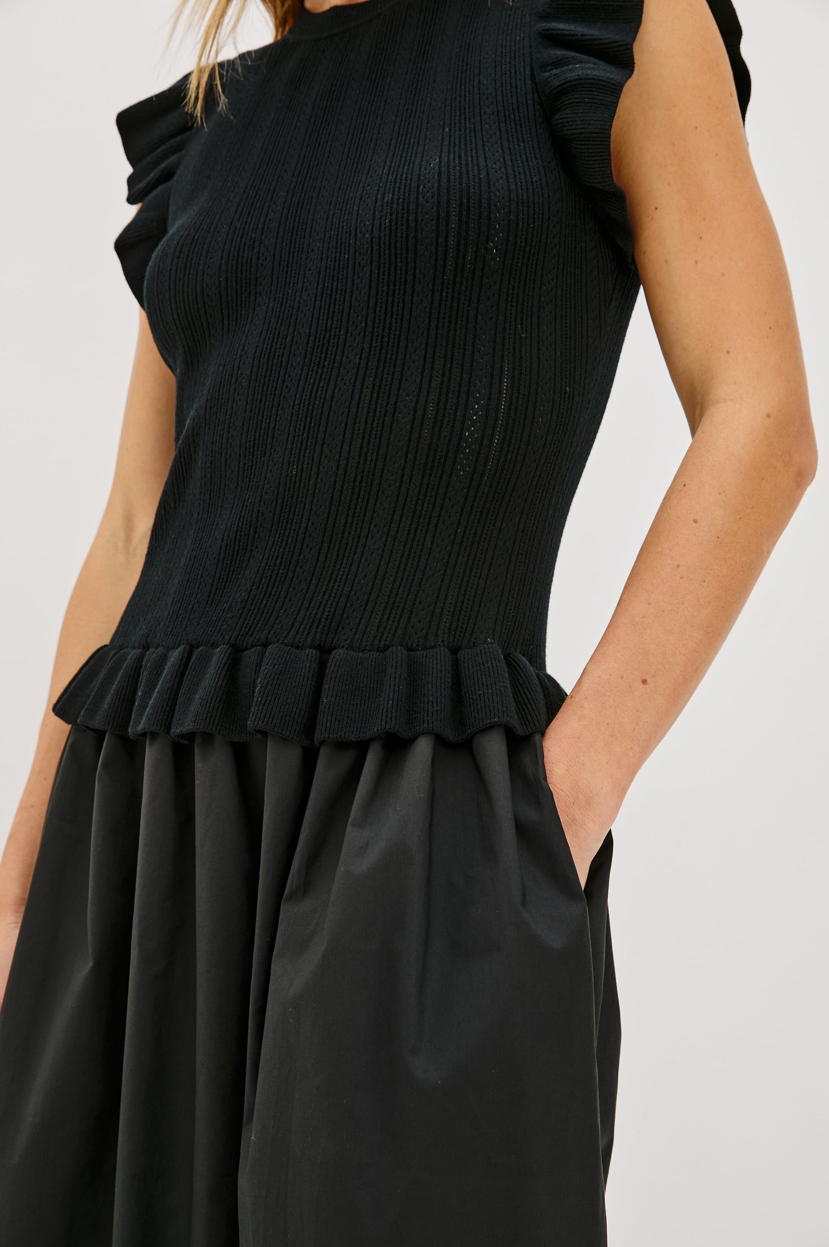 Deirdre, a maxi dress with a fitted fine-gauge knit bodice and flutter sleeves. The dress transitions at the waist into a full cotton poplin skirt, creating a soft, mixed-fabric silhouette. Close Up View featured on Model.