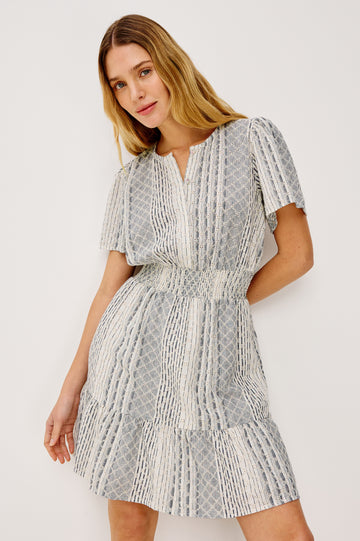 Didi Peasant Style Mini Dress in Luxe Linen With Front Button Placket, Smocked Waist, and Tiered Hem in Striped Eyelet Colorway - Upper Body Front View Featured on Model